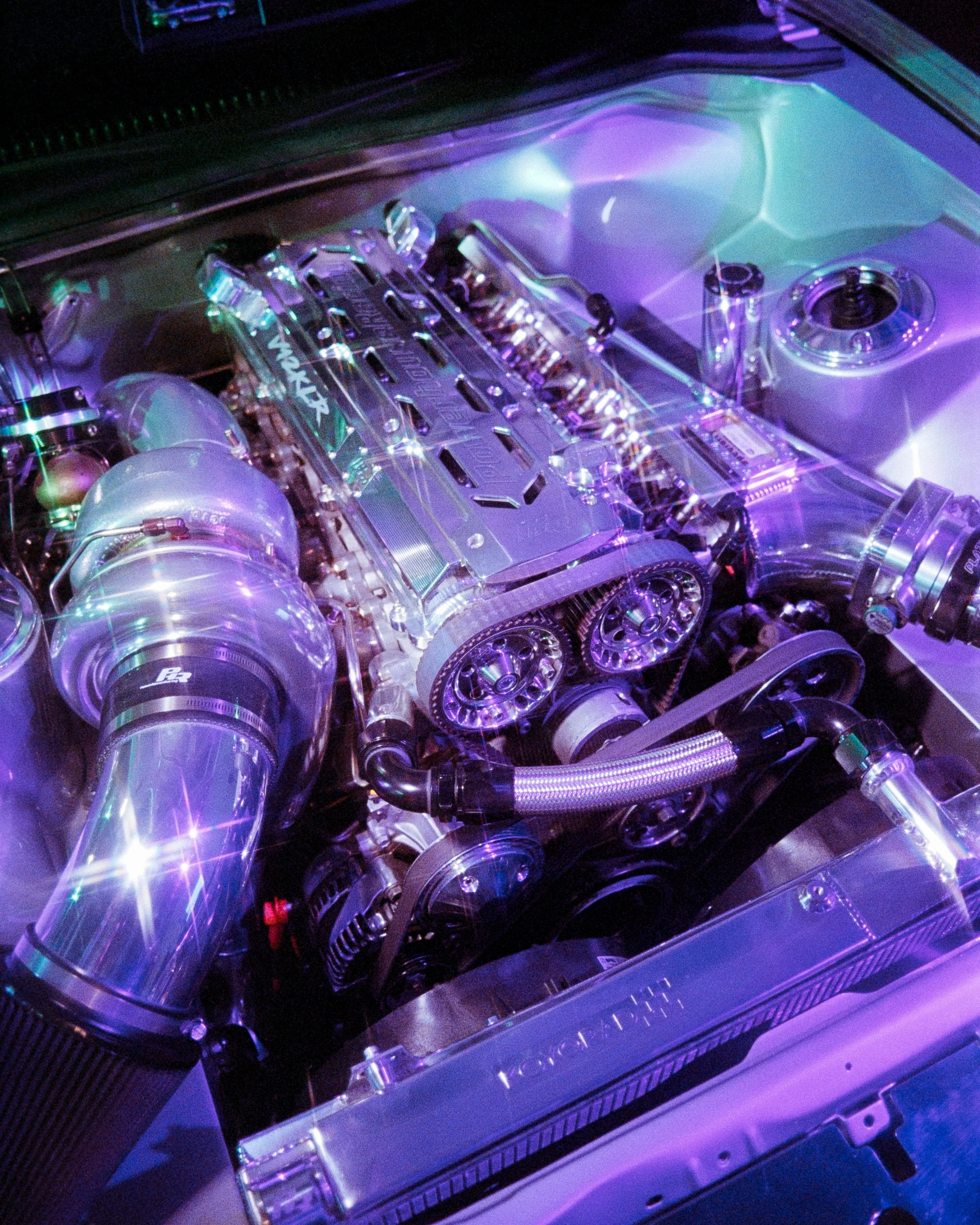 Close up 35mm Film shot on Ultramax of an engine, lit up by purple and teal RGB lights, and covered in shining starbursts from a lens filter