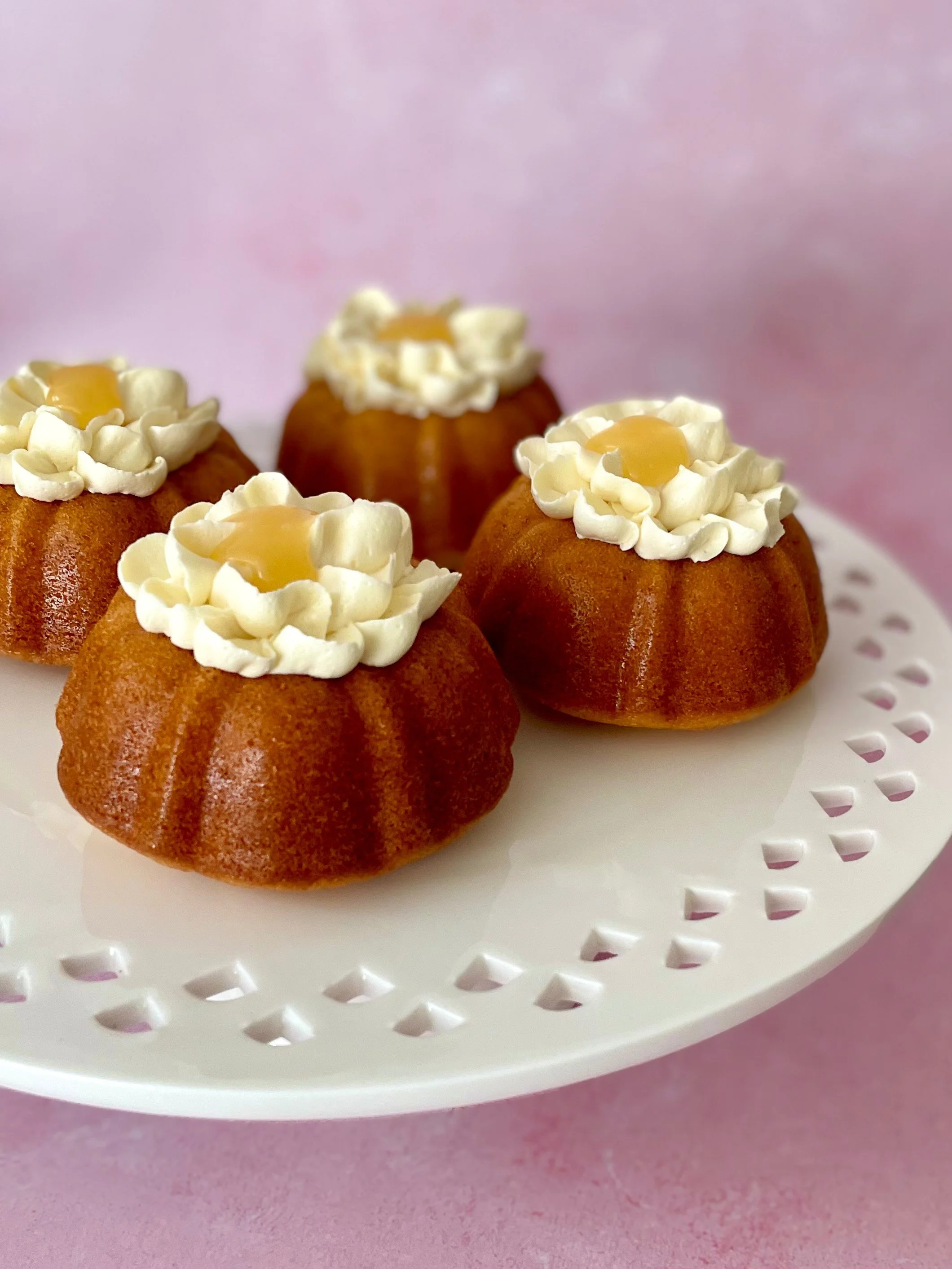 Individual lemon bundt cakes topped with lemon italian meringue buttercream and lemon curd
