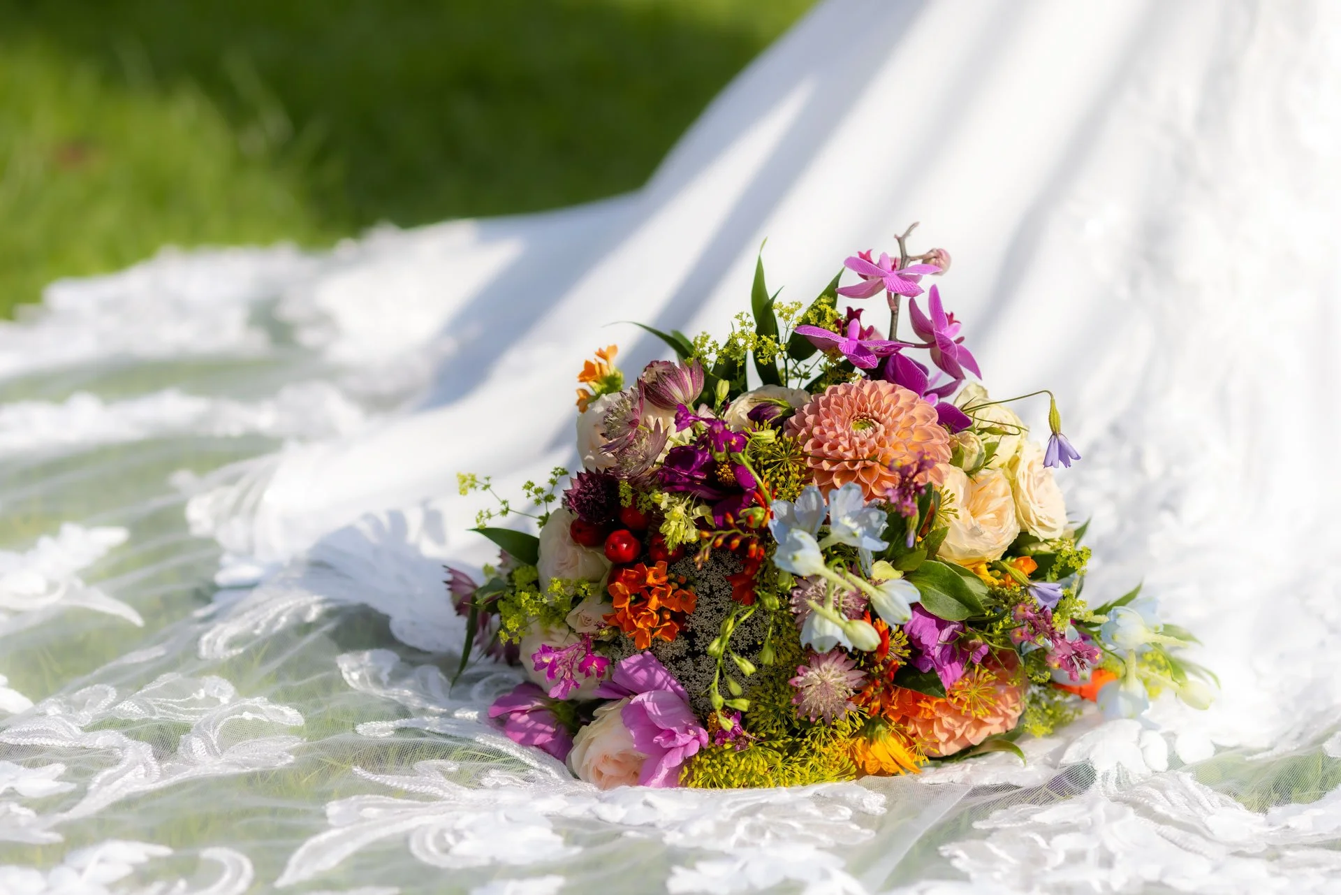 Farvet blomsterbuket på hvidlignet stof med grøn baggrund