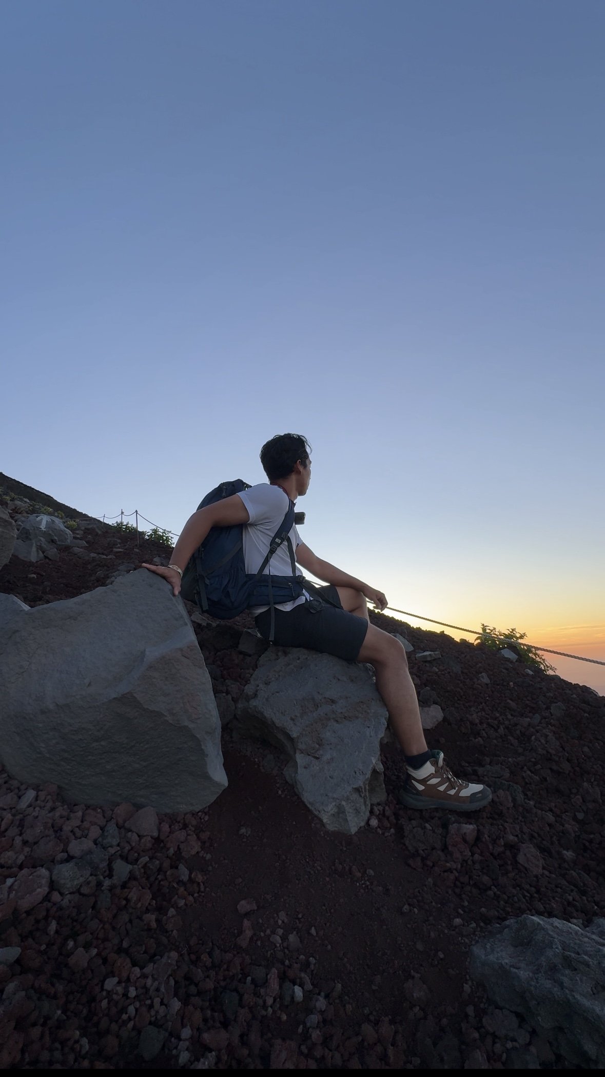 Fujinomiya Trail. seating on a rock while enjoying the view of sunrise.