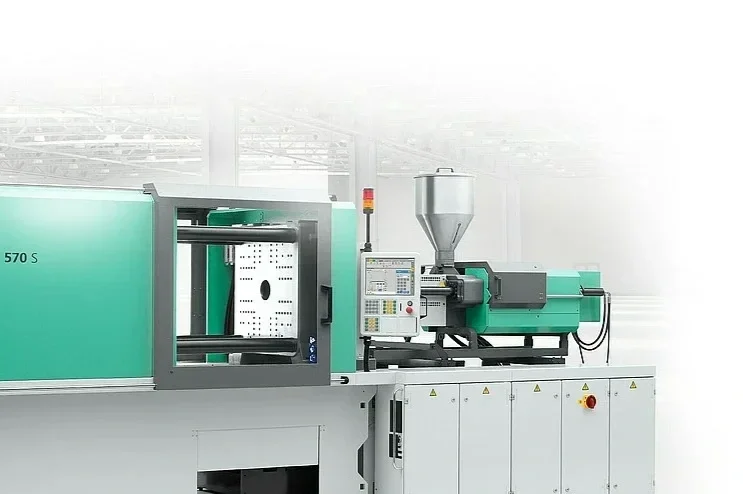 Industrial plastic injection molding machine in a factory setting.