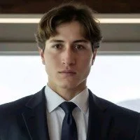 Young man in a suit looking at the camera indoors