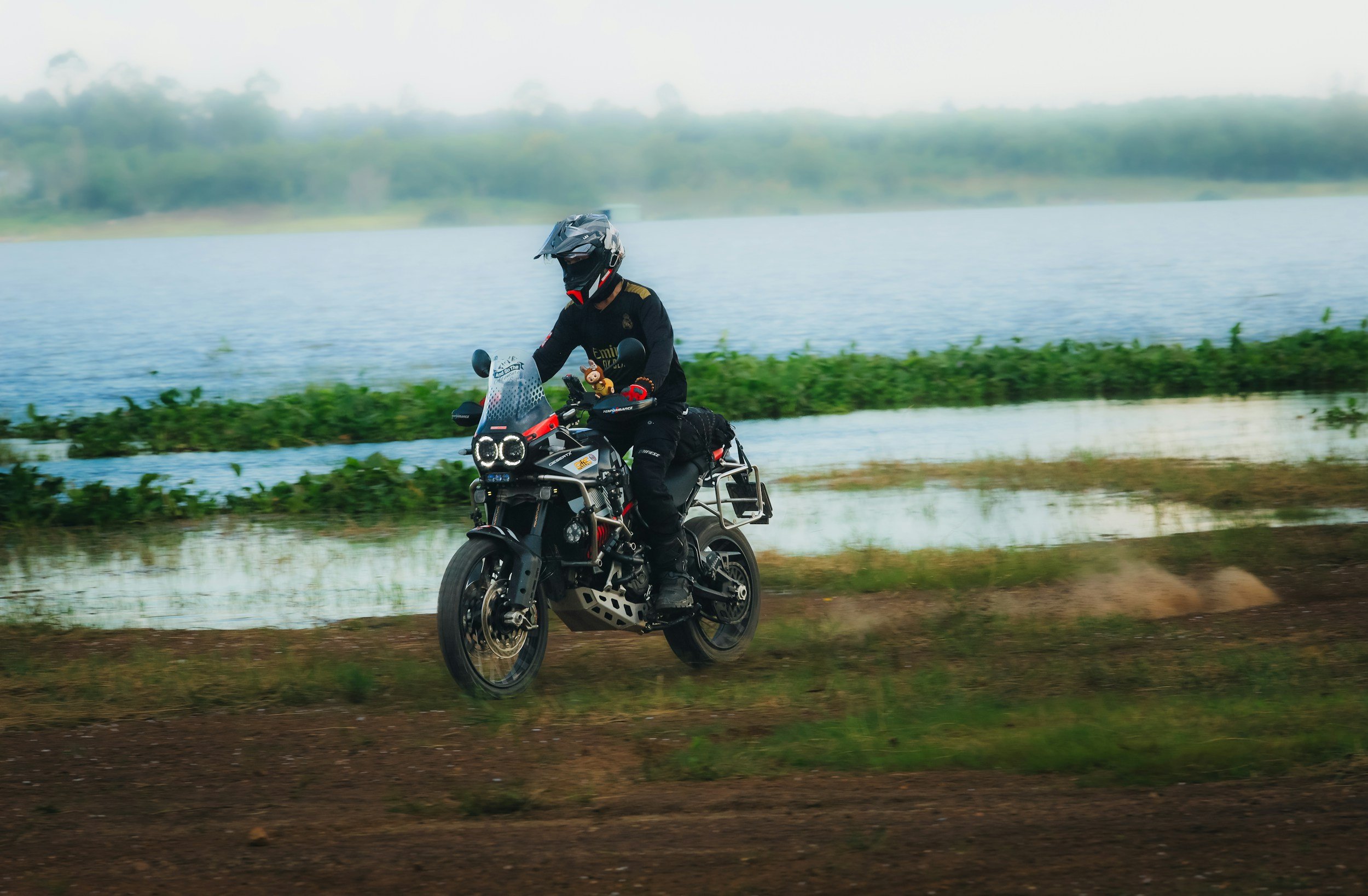 A motorbike rider standing upright, riding on soil, representing leadership adaptability and situational awareness.