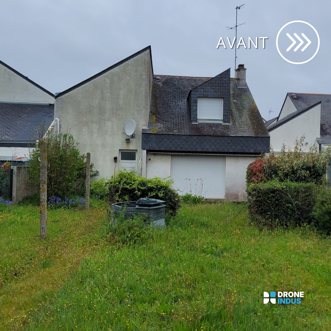 Une maison avec un jardin en façade, des buissons et un composteur, sous un ciel nuageux.