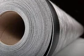 Gros plan sur un grand rouleau de matériau blanc, idéal pour l'étanchéité des piscines, enroulé serré avec un noyau en carton visible.