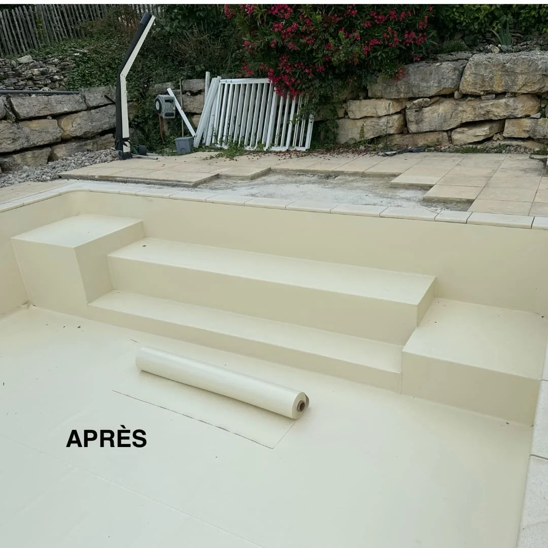 Piscine en rénovation avec nouvelles marches en plastique, un revêtement de sol en construction, et un environnement avec des rochers et des plantes en arrière-plan.