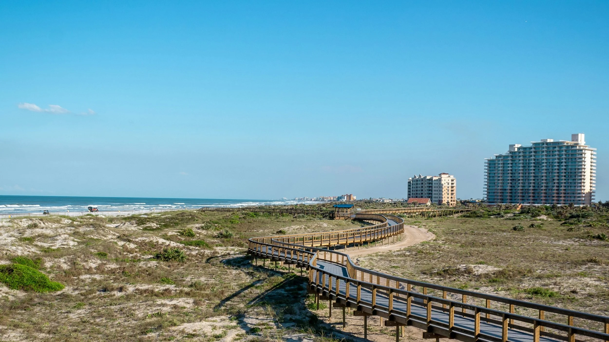 Boardwalk at Smyrna Dunes park, with the New Smyrna coastline in the distance