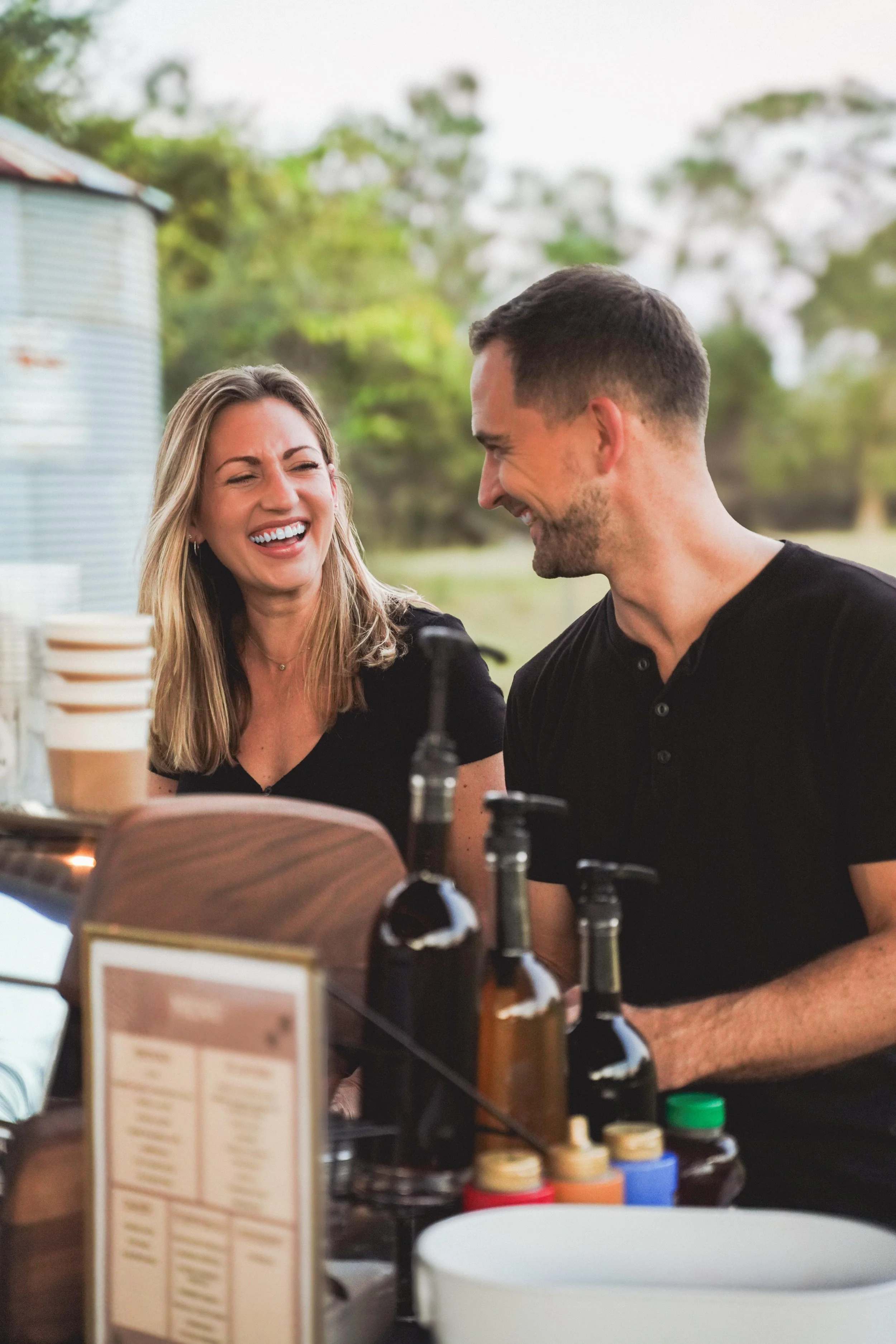 Clint and Kendall Proctor smiling and and preparing drinks