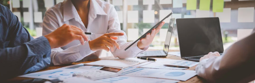 Gens d'affaires en réunion avec documents, ordinateur portable et téléphone.