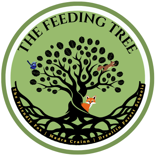 A circular logo for The Feeding Tree featuring a black tree with many leaves on a green background, a fox at the base, a bluebird on a branch, and a squirrel on another branch, with text around the circle.