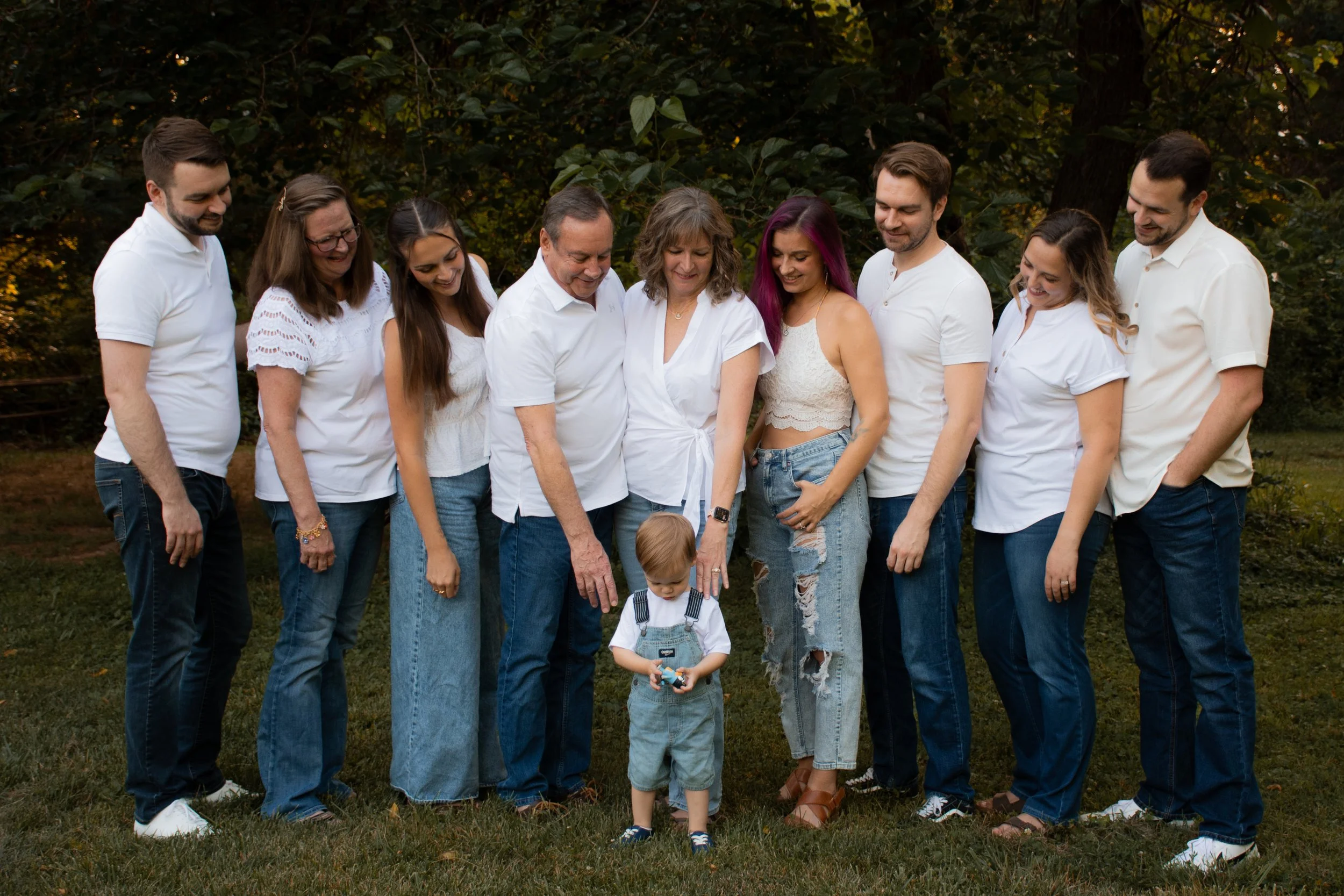 An extended family of ten in white and denim, a toddler standing in front