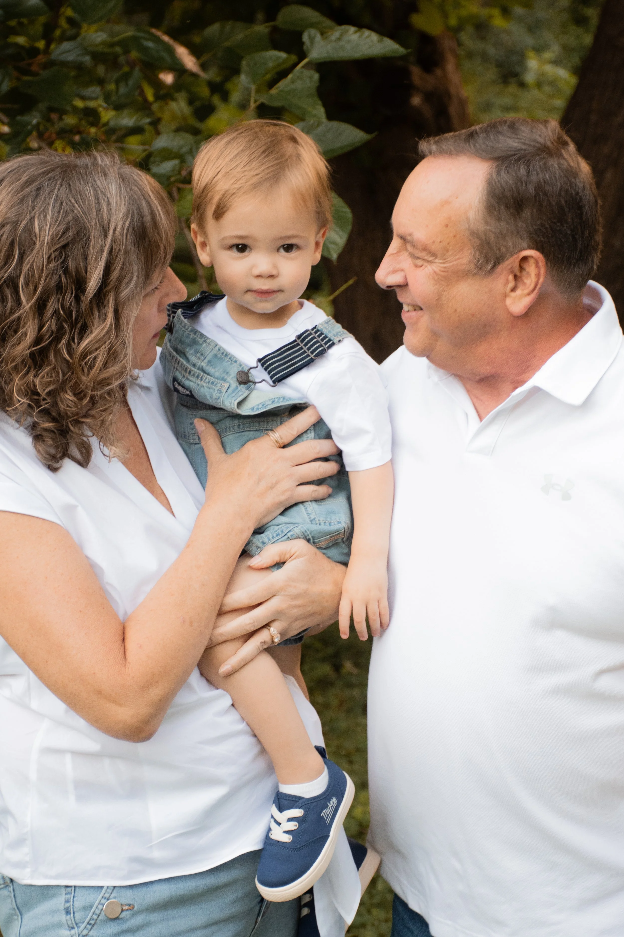 Grandparents holding their toddler grandchild between them
