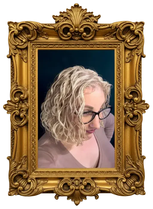 A woman with blonde curly hair and glasses taking a selfie, viewed from above, in a gold ornate frame.