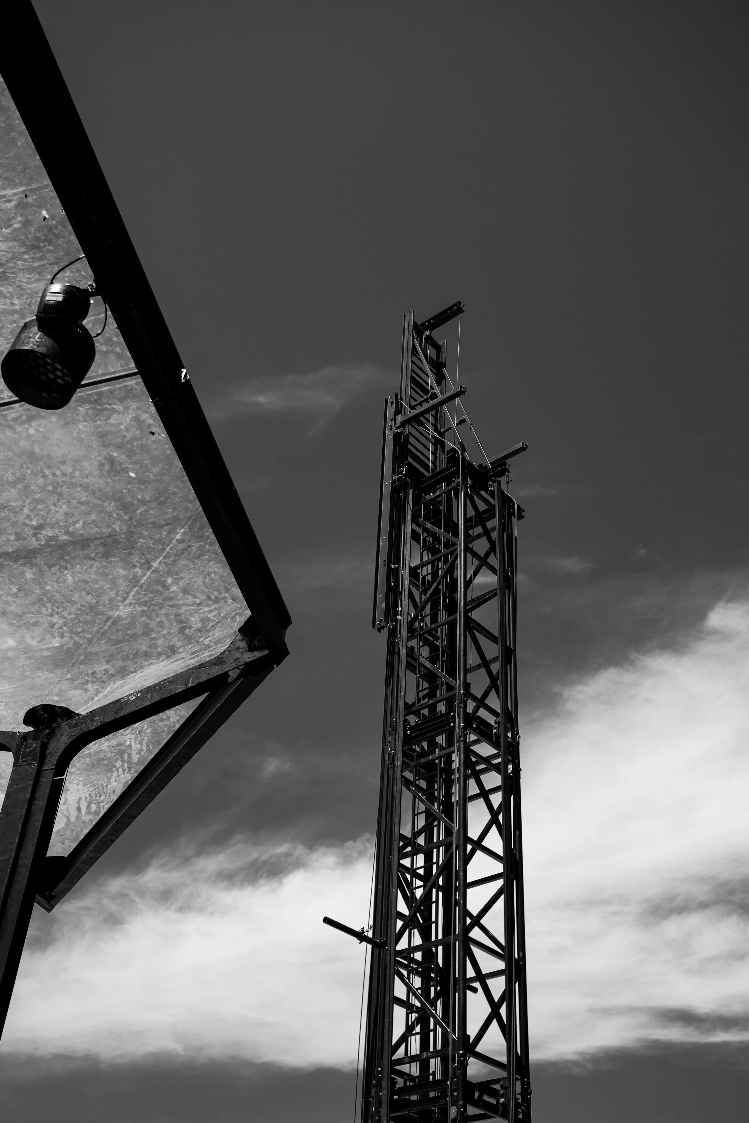 Black and white photo of stage tower against a cloudy sky.