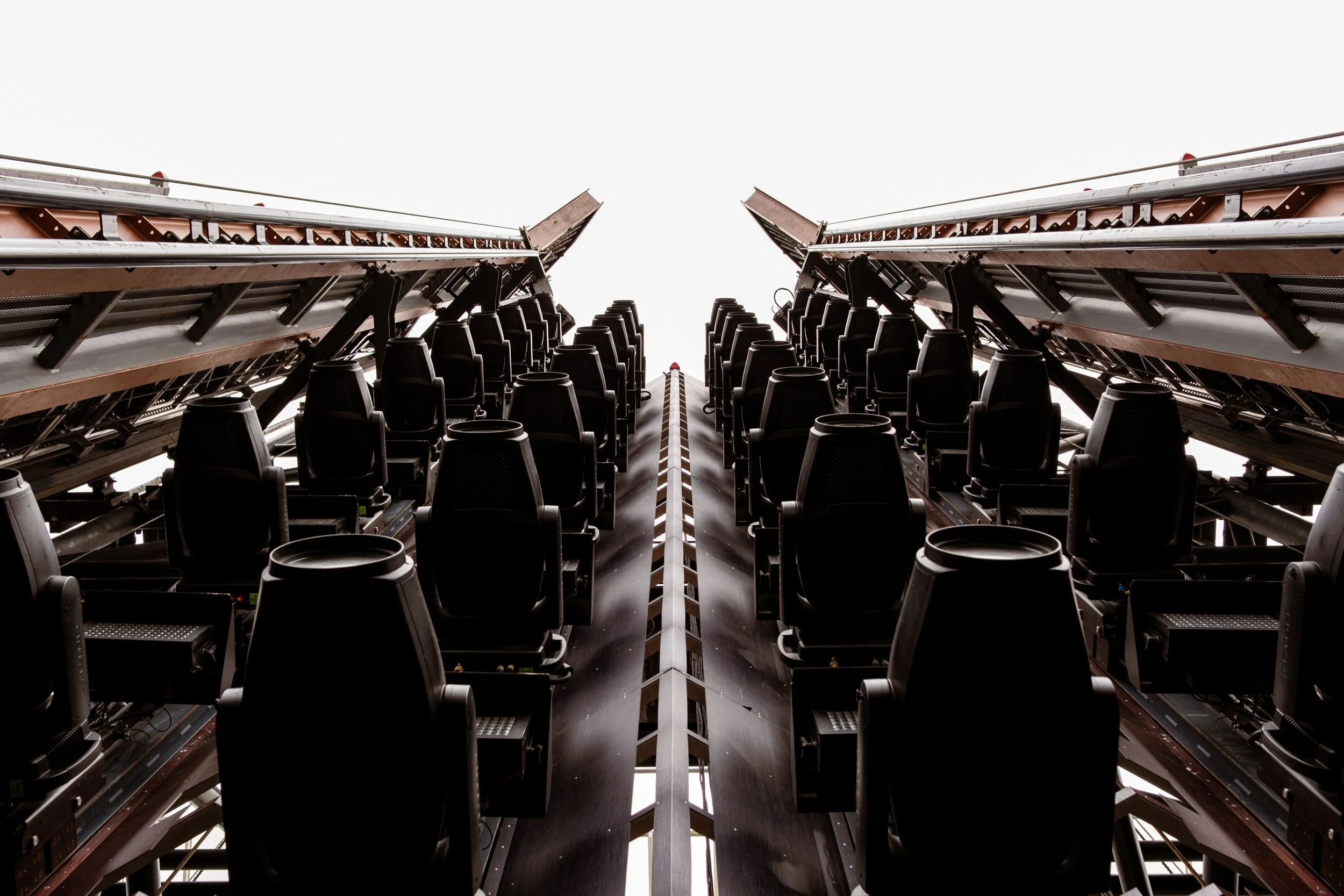 Looking up at a row of concert or theater seats with a bright white sky in the background.