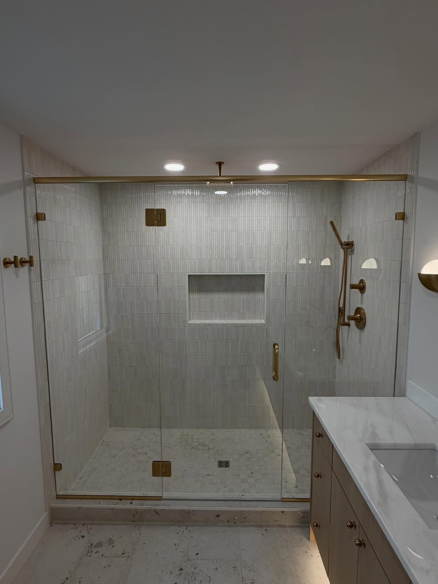 Three Panel Enclosure with header and brushed bronze hardware #seattleglasscompany #seattleshowerglass #showerglass #showerglassenclosure #smallbusiness