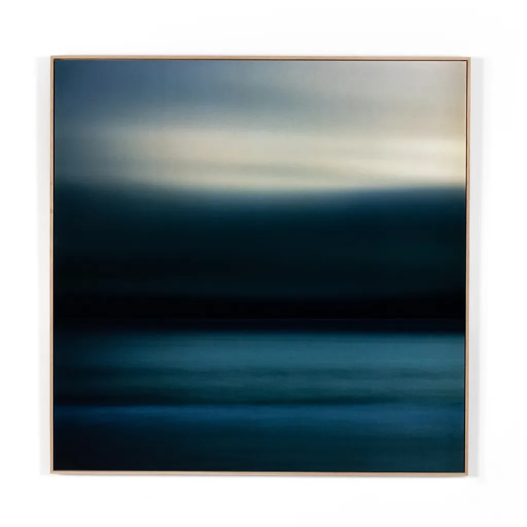 An abstract painting with horizontal bands of blue, gray, and black colors, framed in light wood.