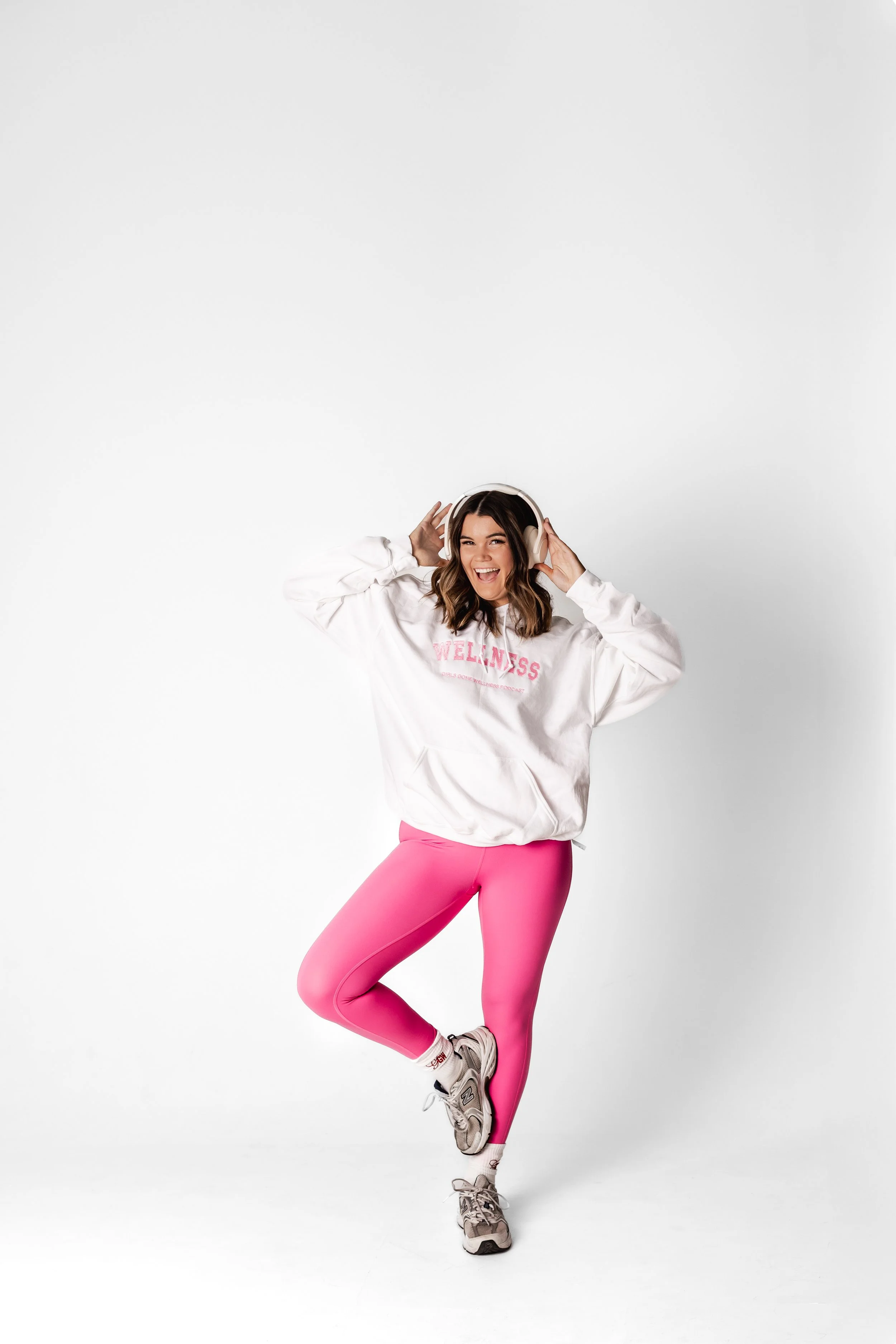 girl wearing wellness white hoodie with pink embroidery