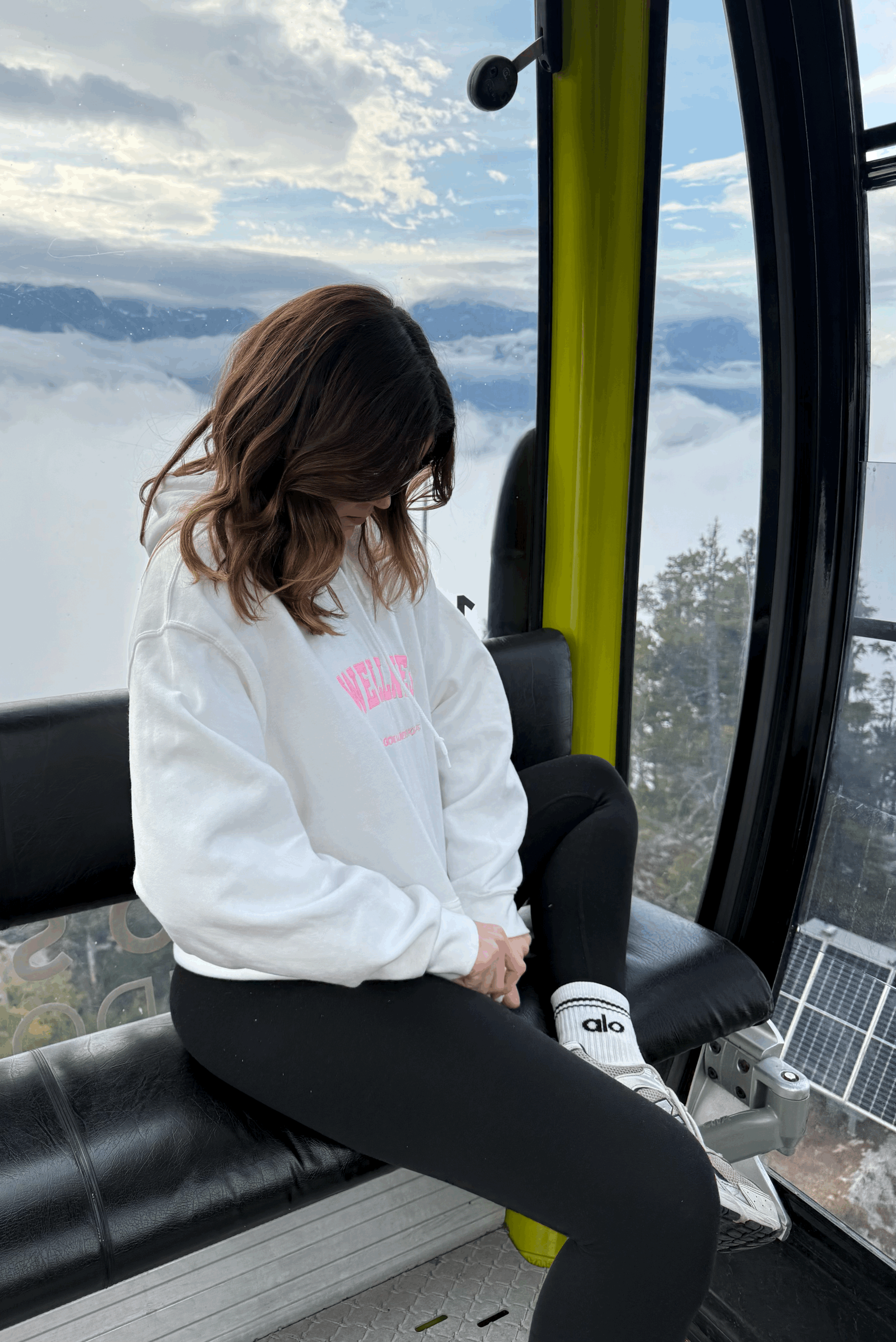 girl wearing wellness white hoodie with pink embroidery