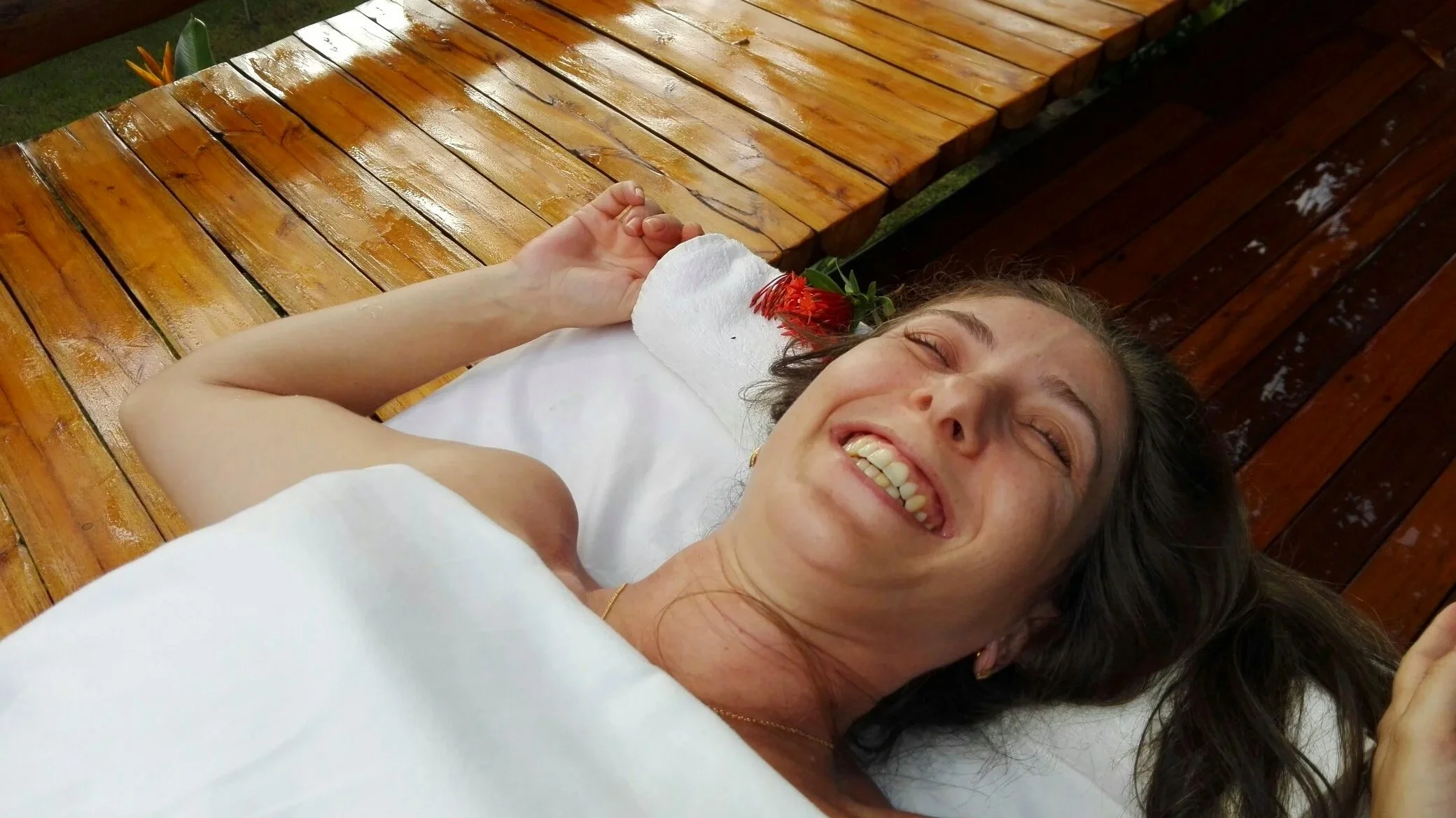 Giovane donna serena e distesa sul lettino da massaggio simbolo del sollievo e del benessere che seguono il trattamento, anche quando l’indolenzimento muscolare rientra nelle normali reazioni del corpo