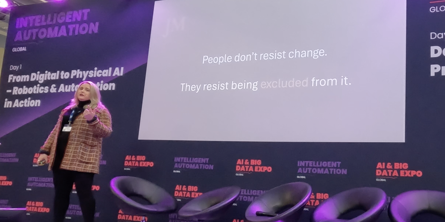 A woman giving a presentation on stage at an AI and Big Data Expo, with a screen displaying a quote about resistance to change in technology.