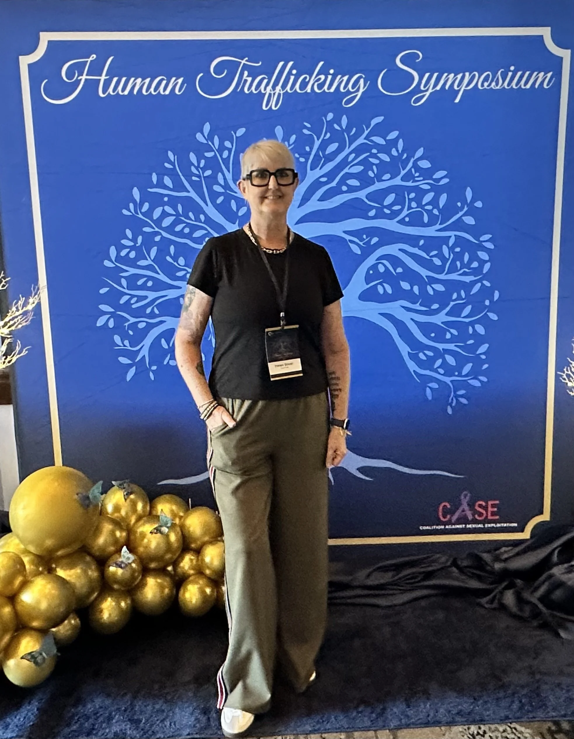 Helen Stiver standing in front of a blue backdrop 