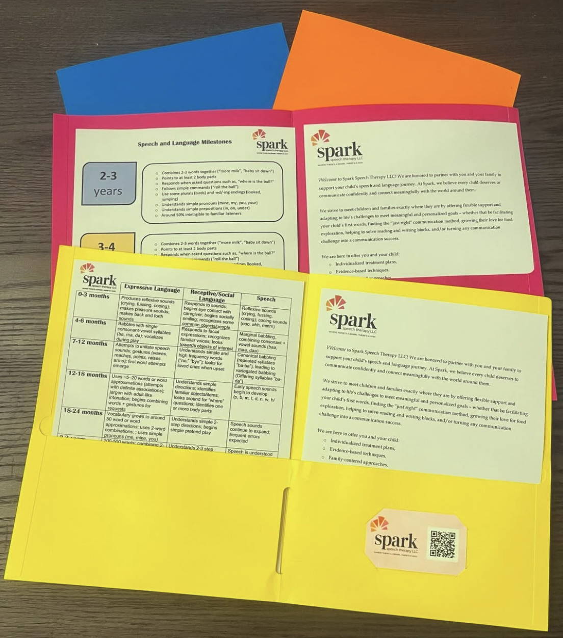 A person with curly hair writing in a notebook, sitting on a red chair.