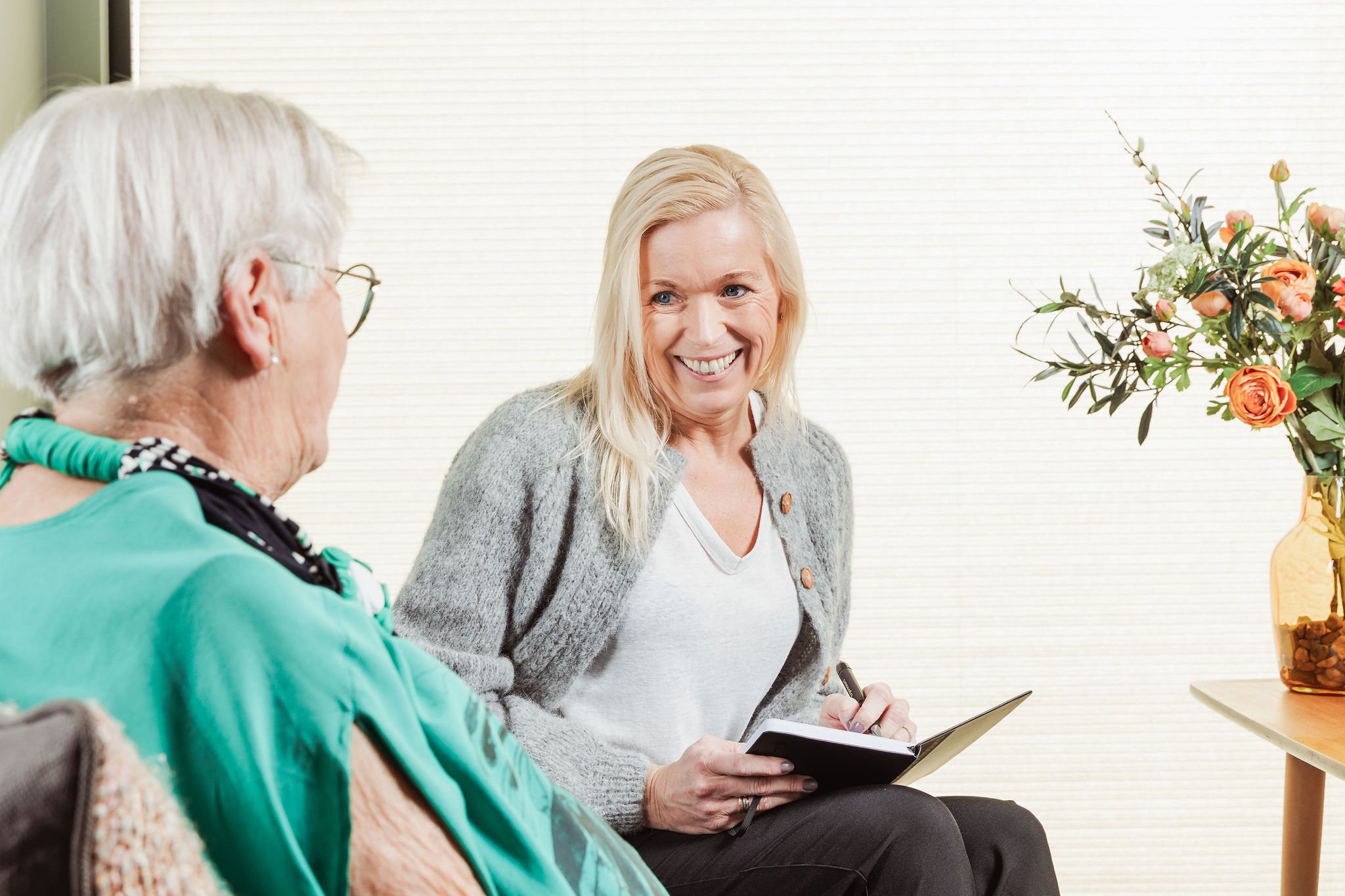 Ergoterapeut i samtale med eldre person og pårørende for å gi faglig trygghet og personlig veiledning som supplement til kommunale tjenester