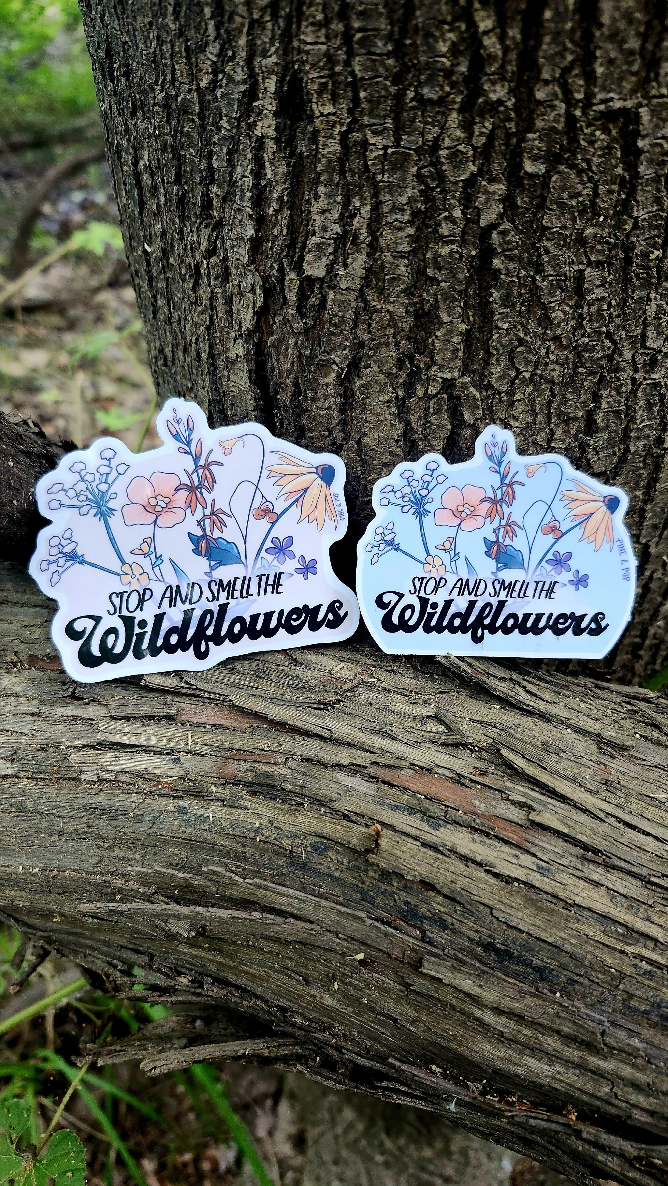 both the light blue and cream versions of the stop and smell the wildflowers stickers sitting next to each other