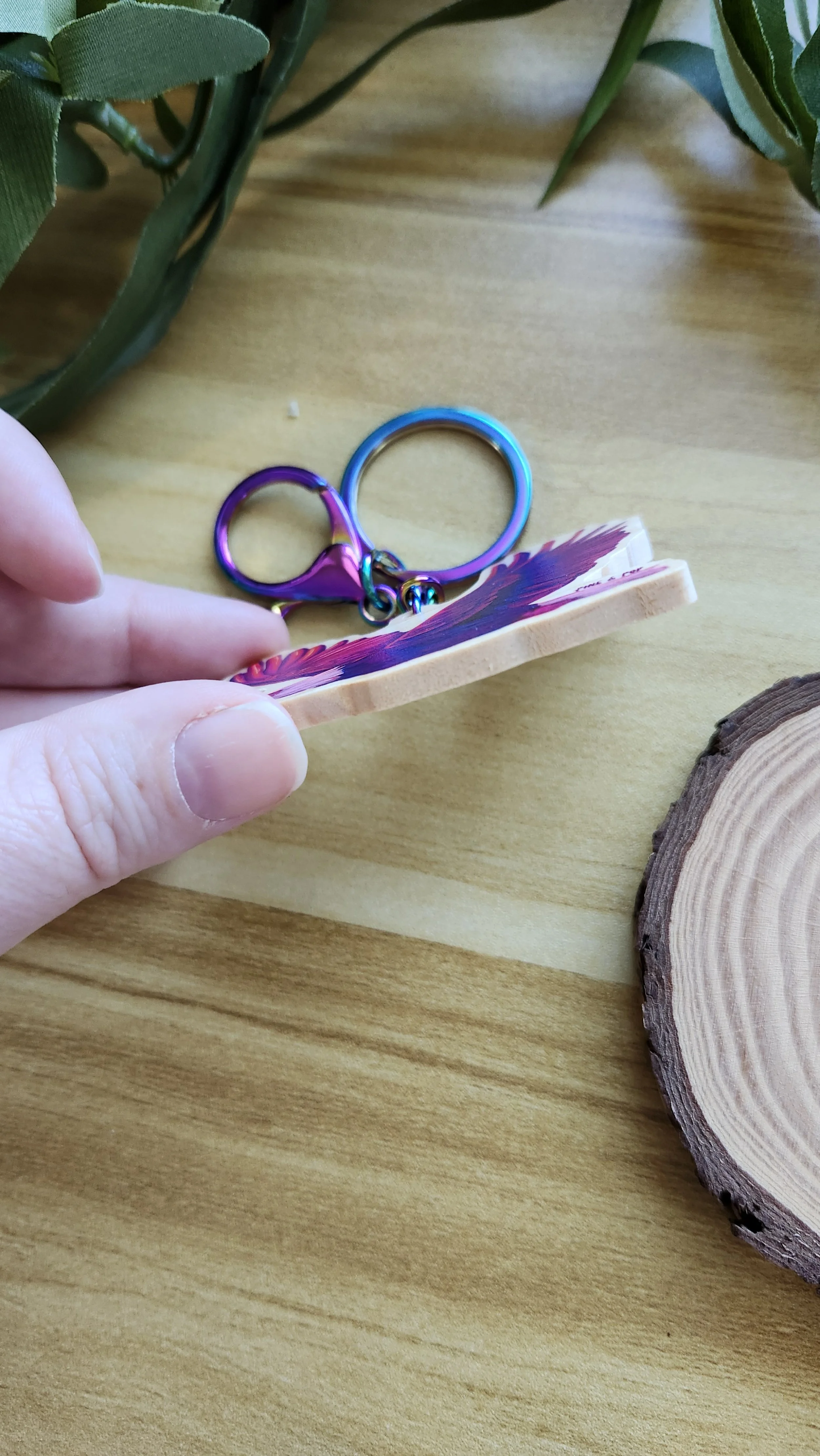 hand holding keychain to show the wooden edge and thickness