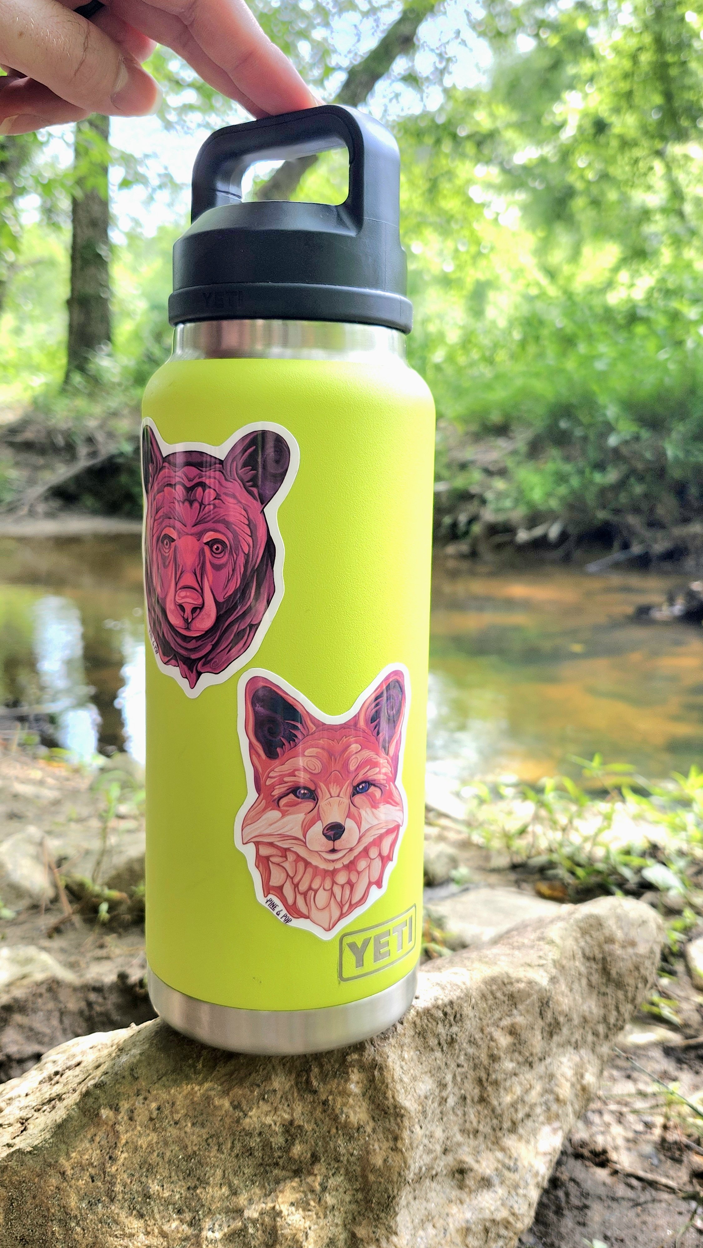 the fox head sticker on a water bottle in the outdoors