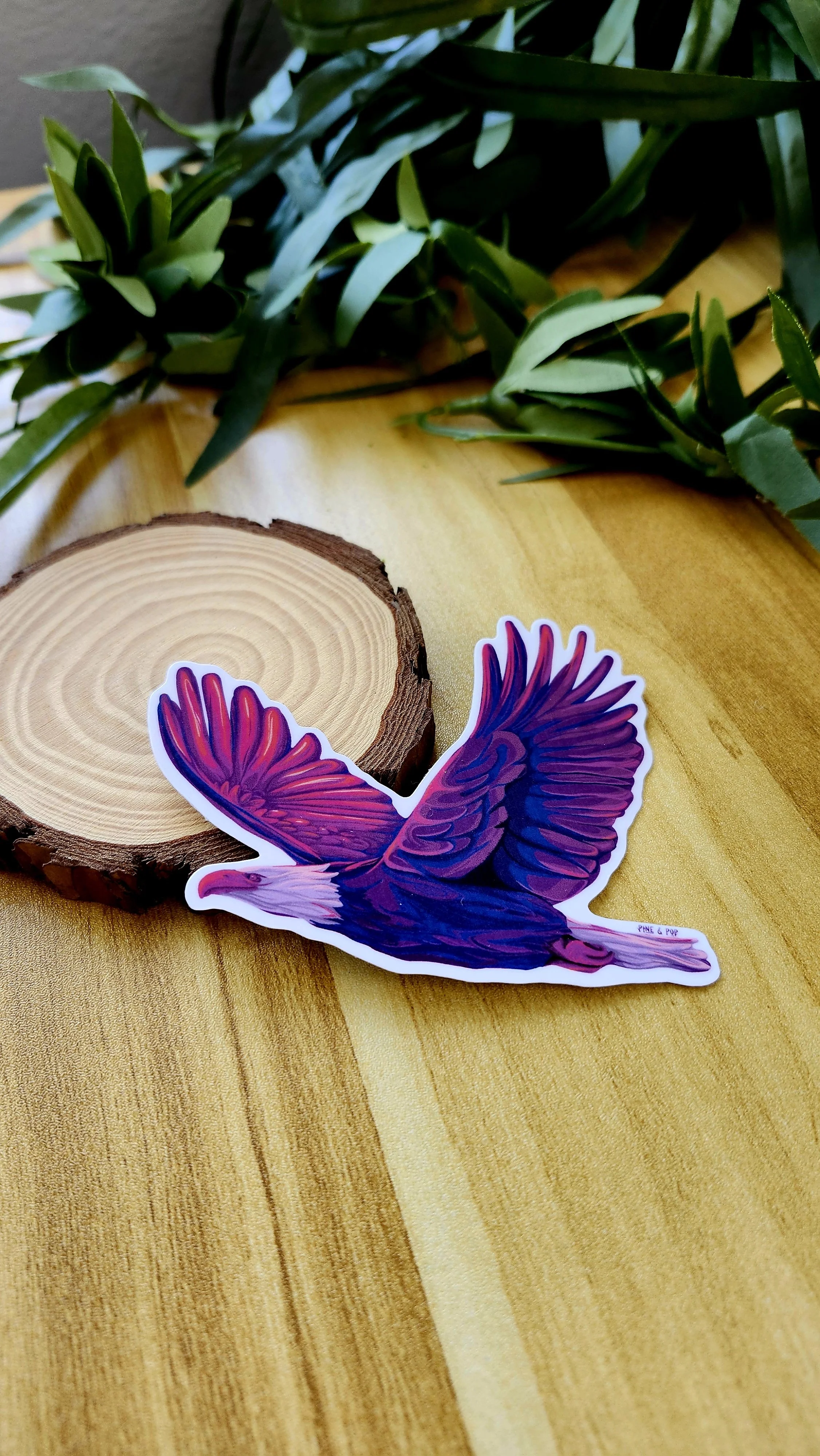 another view of a sticker of a bald eagle in flight with bold purple and pink colors