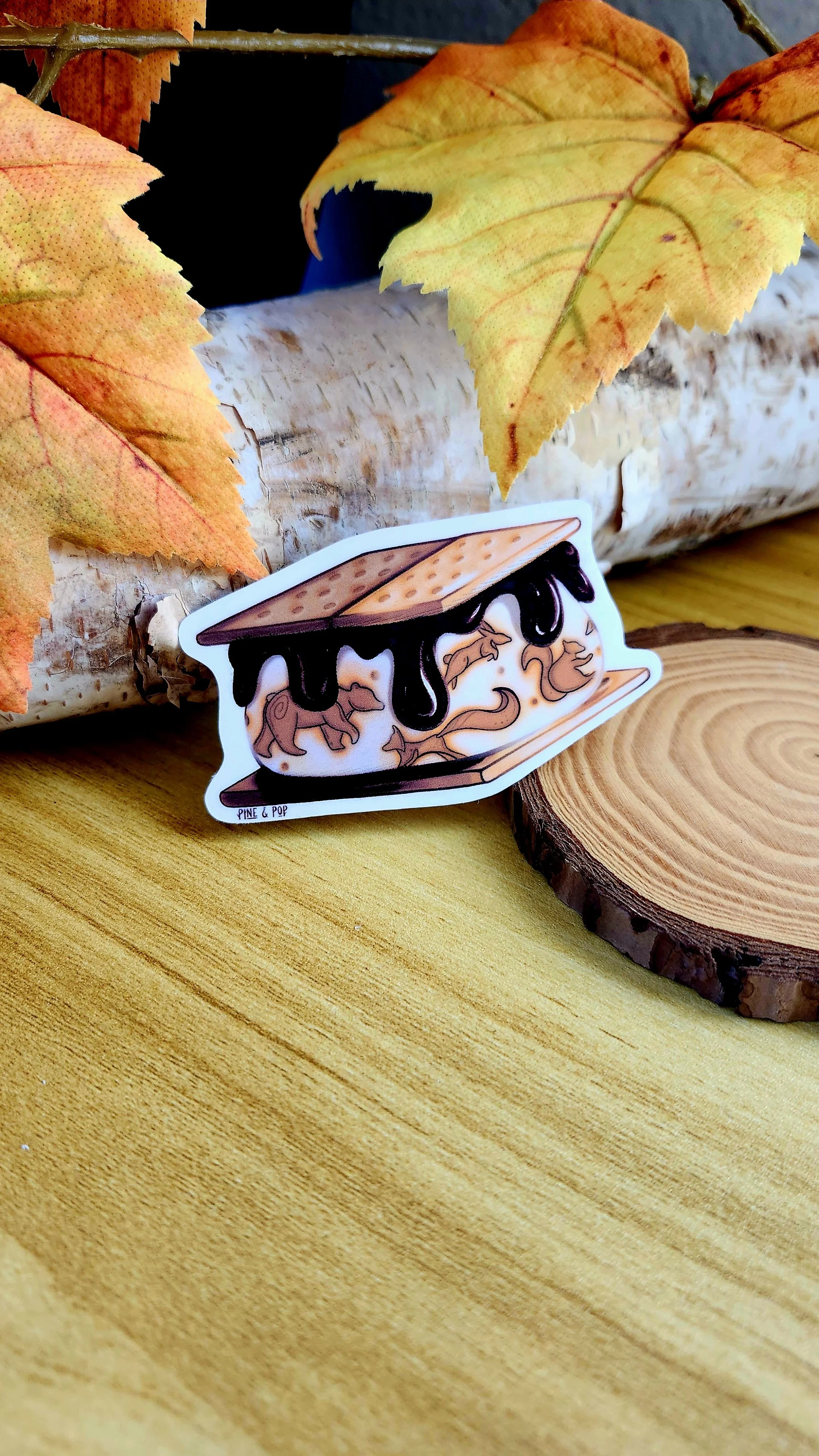 S'more sticker laying against a section of tree