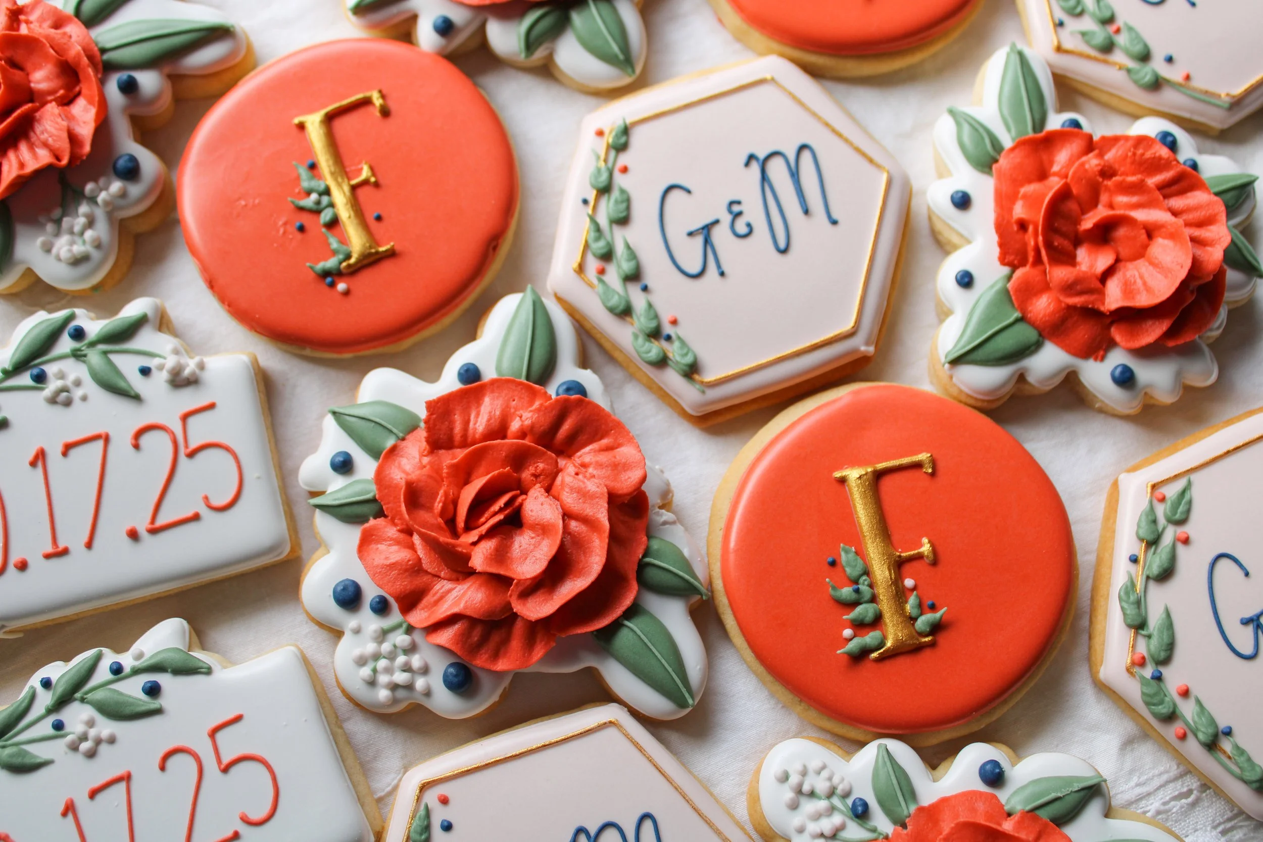 Decorated wedding cookies with initials, date, fall colors, and floral designs.