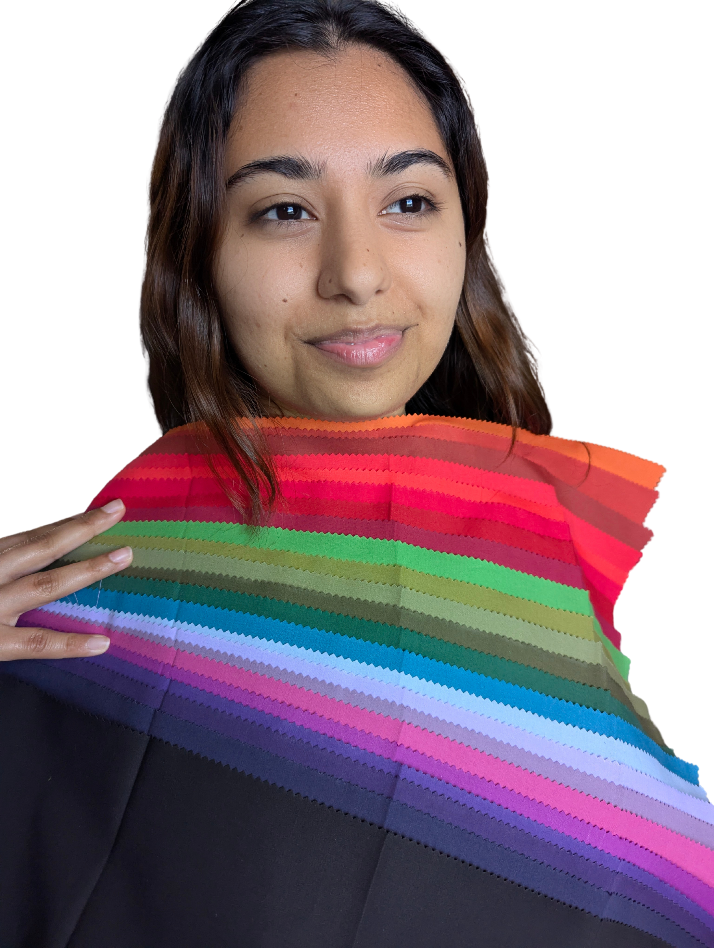 Young woman with brown hair holding a rainbow-colored fabric with a zigzag pattern near her shoulder, against a dark background.