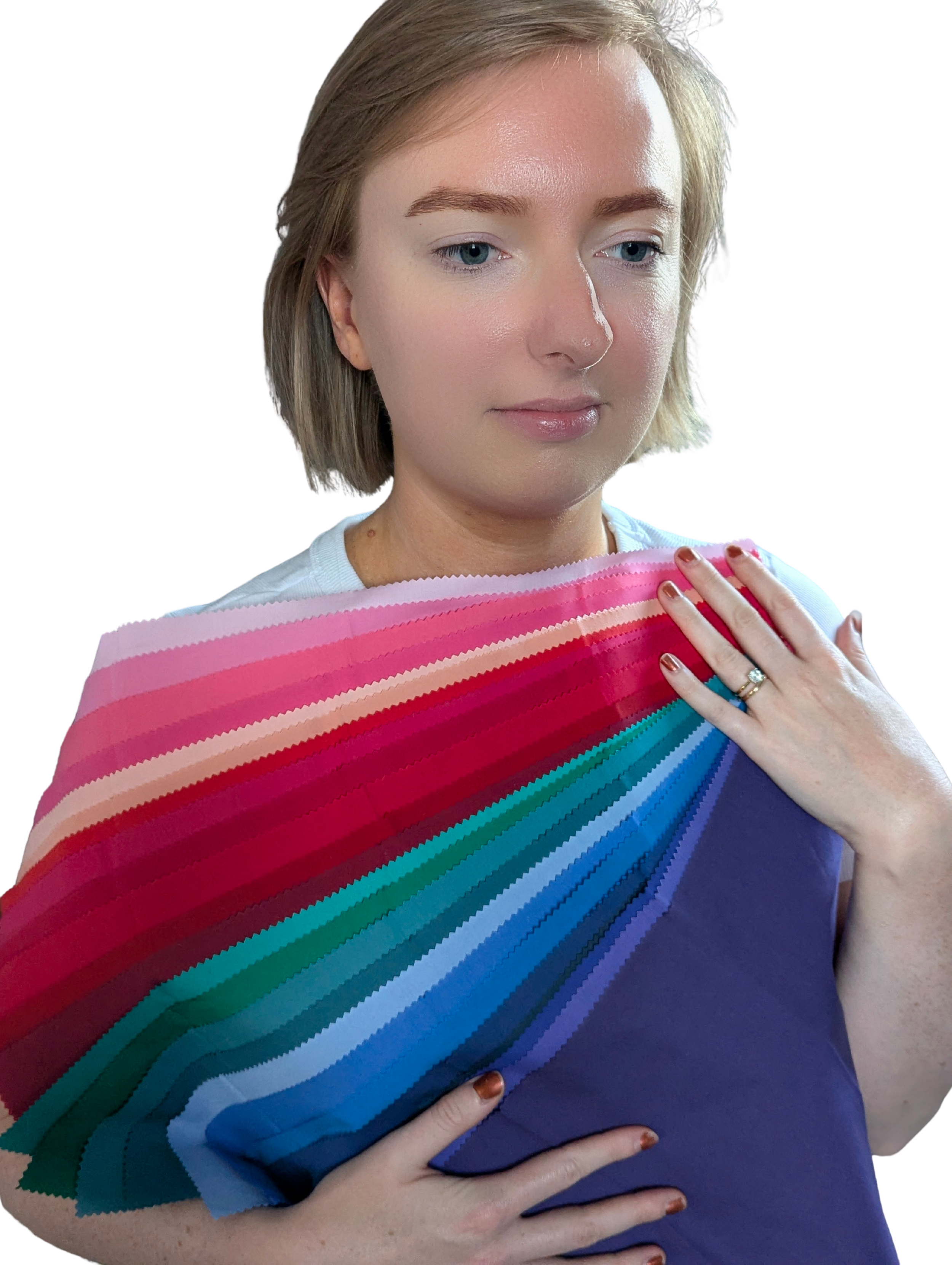 A woman with blonde hair and a white shirt holding a large color swatch palette with various shades of pink, blue, purple, green, and beige.
