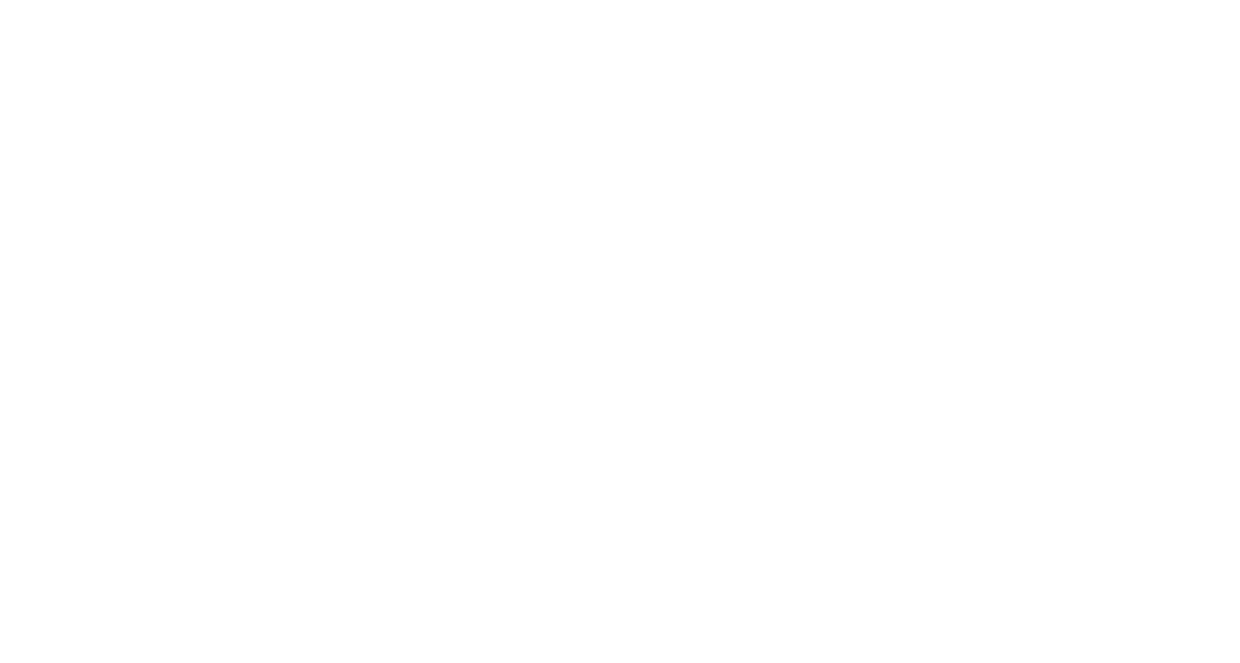 A person in a bright green shirt and red hat, holding the hand of a young girl in a pink dress, as they walk on a trail through lush greenery and trees