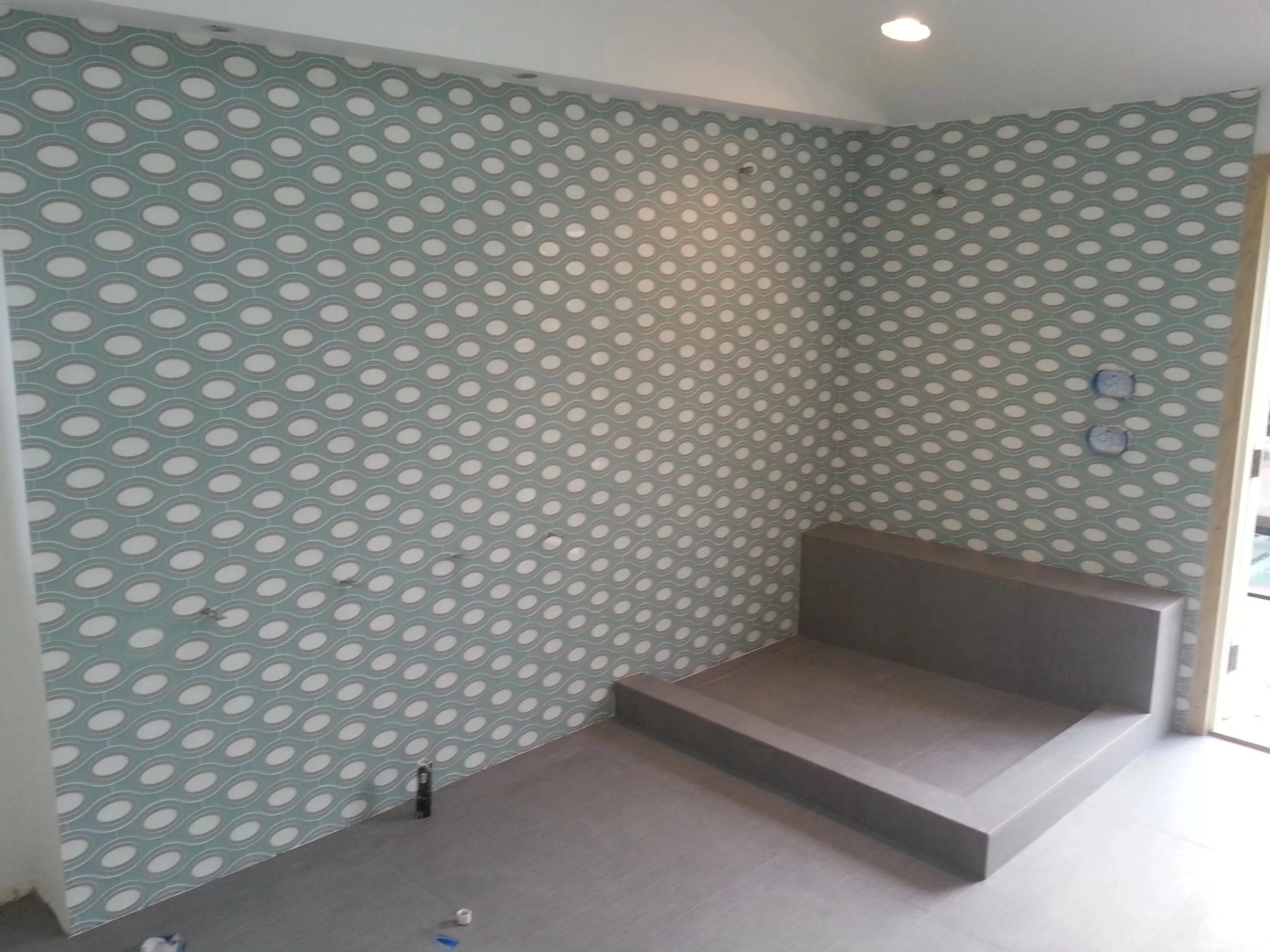 Picture of a glass tile shower with a bench.