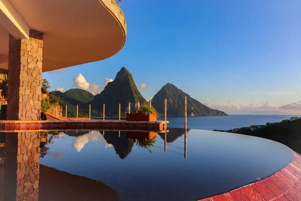 Luxury infinity pool overlooking the iconic Piton mountains and Caribbean Sea in Saint Lucia, with breathtaking sunset views and tropical scenery.
