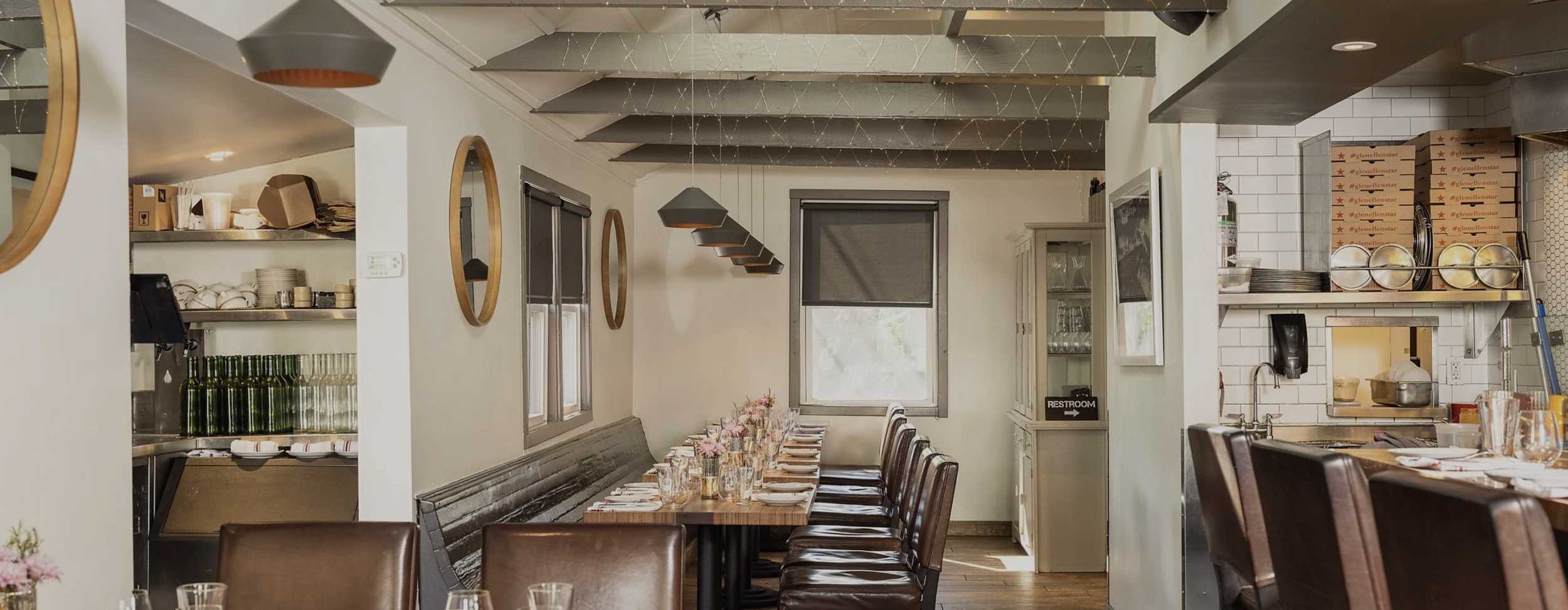 Interior of Glen Ellen Star in Sonoma County featuring an open kitchen, rustic-modern dining room, communal table seating, and a warm, inviting atmosphere.
