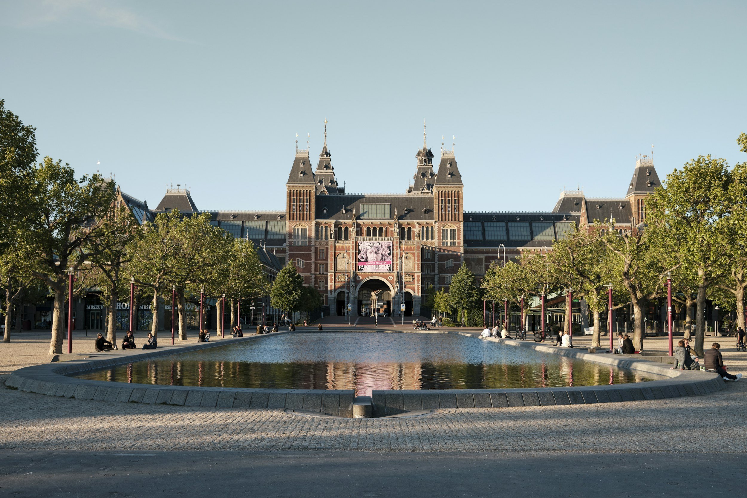 Rijksmuseum Amsterdam exterior with reflecting pool at Museumplein, showcasing its iconic Dutch architecture and central archway.