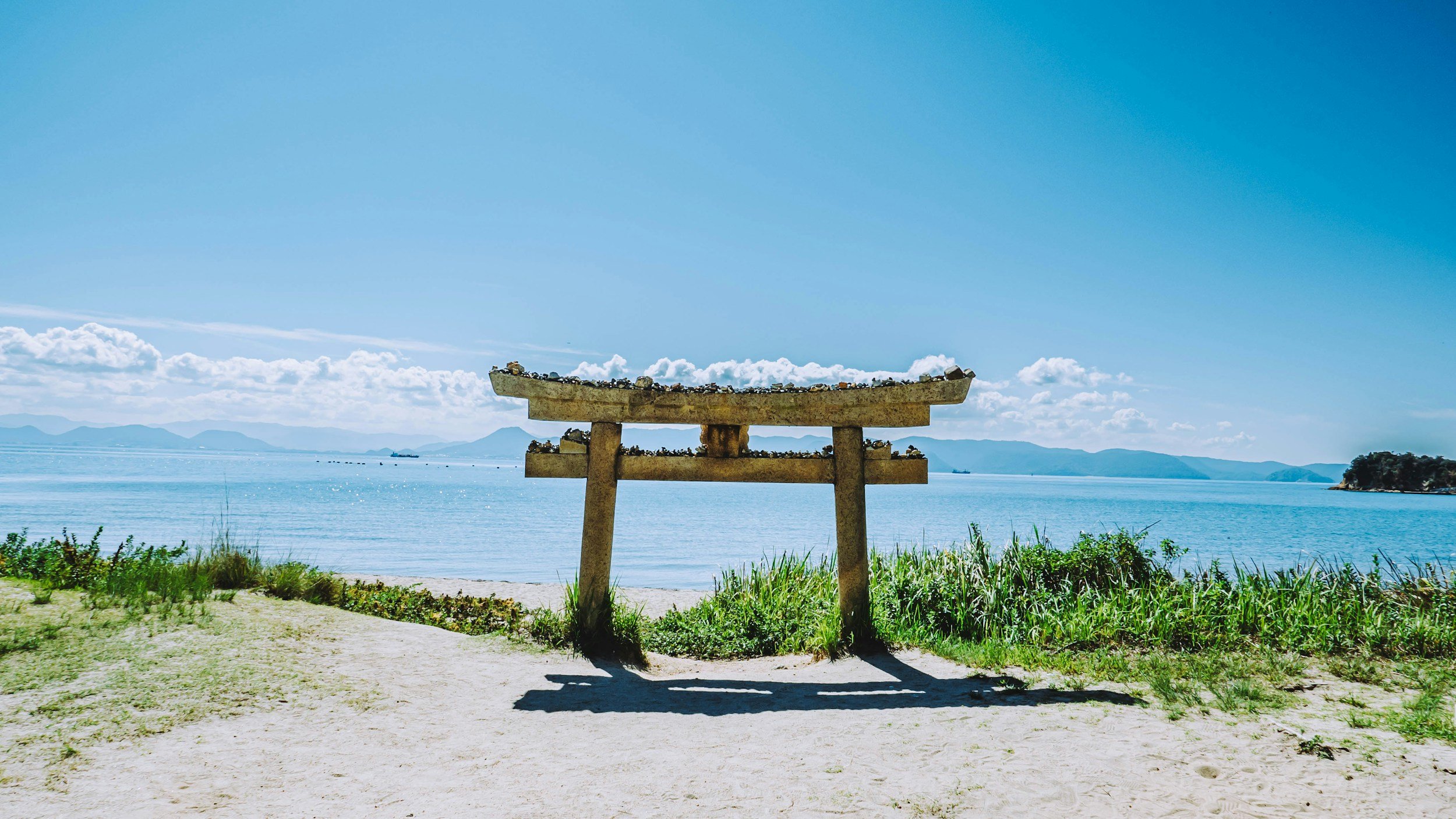 Torii gate on a quiet beach overlooking Lake Biwa in Japan