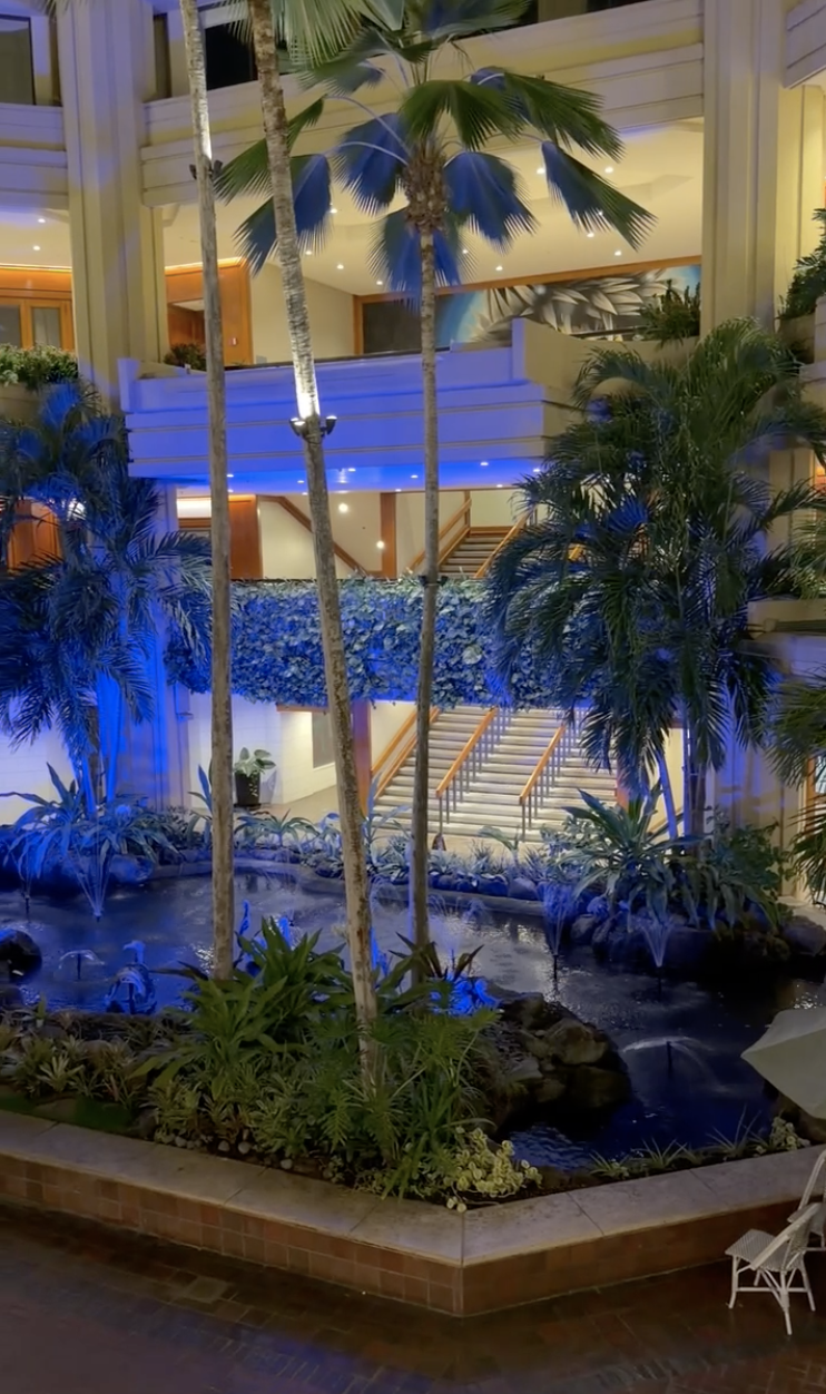 Lobby at Hyatt Regency Waikiki Beach Resort & Spa featuring an open-air atrium, modern Hawaiian design, and views of Waikiki Beach in Honolulu, Oahu.