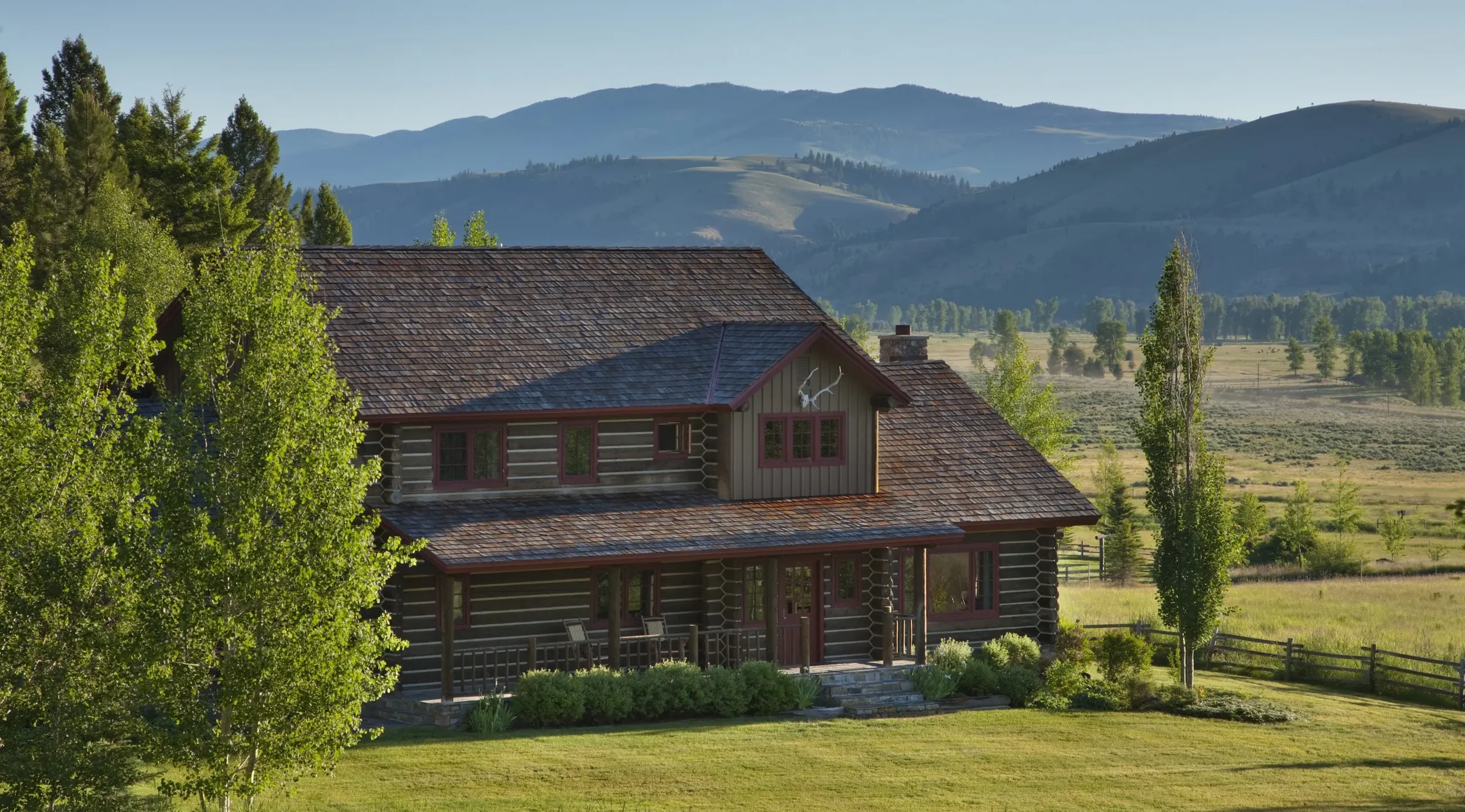 Luxury log cabin at The Ranch at Rock Creek surrounded by open fields and mountain views in Montana