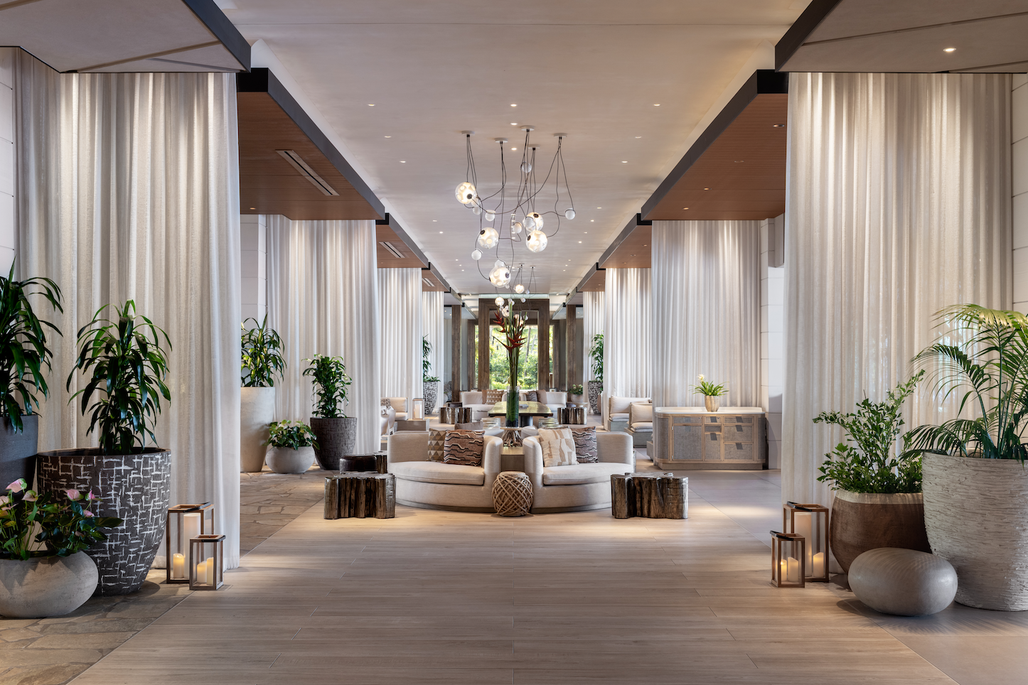 Lobby of The Ritz-Carlton Turtle Bay with tall white columns, neutral lounge seating, tropical plants, and an airy coastal-luxury design.