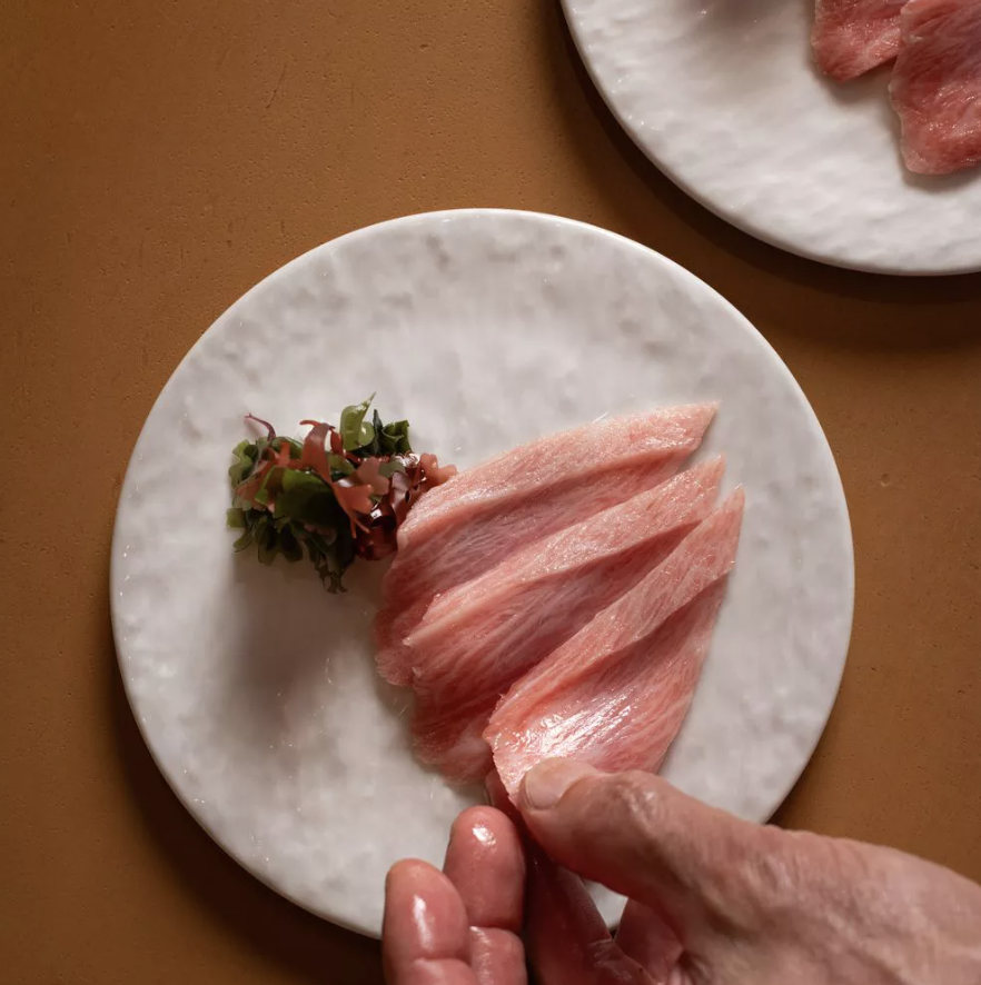 Delicately sliced premium tuna is artfully presented on a marble plate, highlighting the freshness, craftsmanship, and refined culinary experiences found in Los Angeles’ acclaimed dining scene.