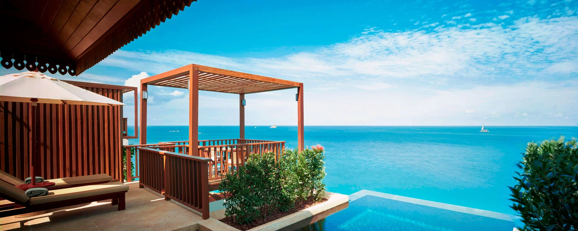 Oceanfront villa at The Ritz-Carlton, Koh Samui featuring a private infinity pool, wooden pergola, and panoramic views of the turquoise sea—ideal for a romantic Thailand retreat.