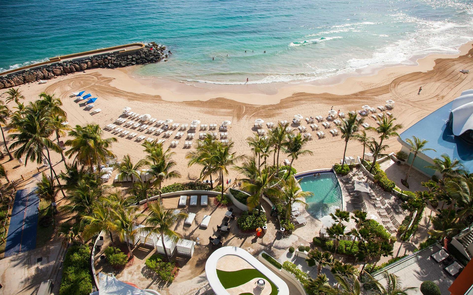 Lagoon-style pools, palm trees, and oceanfront views at the Fairmont El San Juan Hotel in Puerto Rico—perfect for Caribbean vacations and resort getaways.