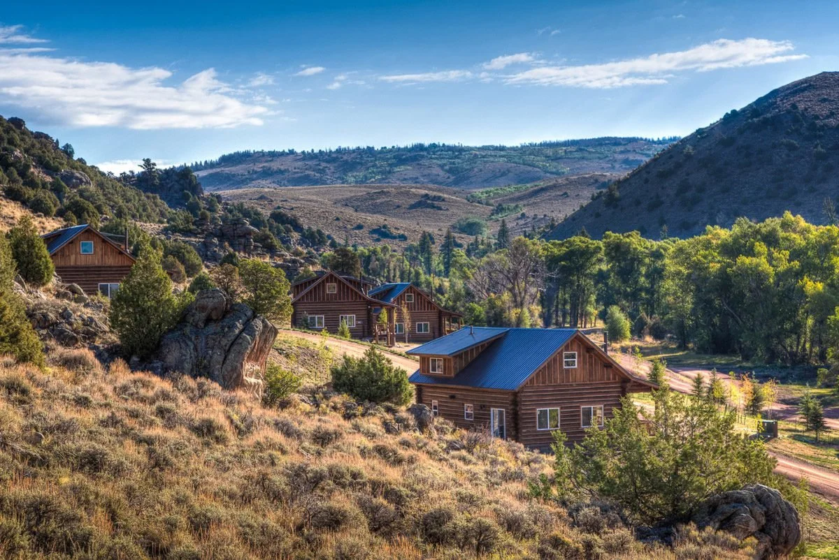 Luxury cabins at The Lodge & Spa at Brush Creek Ranch set in scenic Wyoming countryside with rolling hills and mountain views