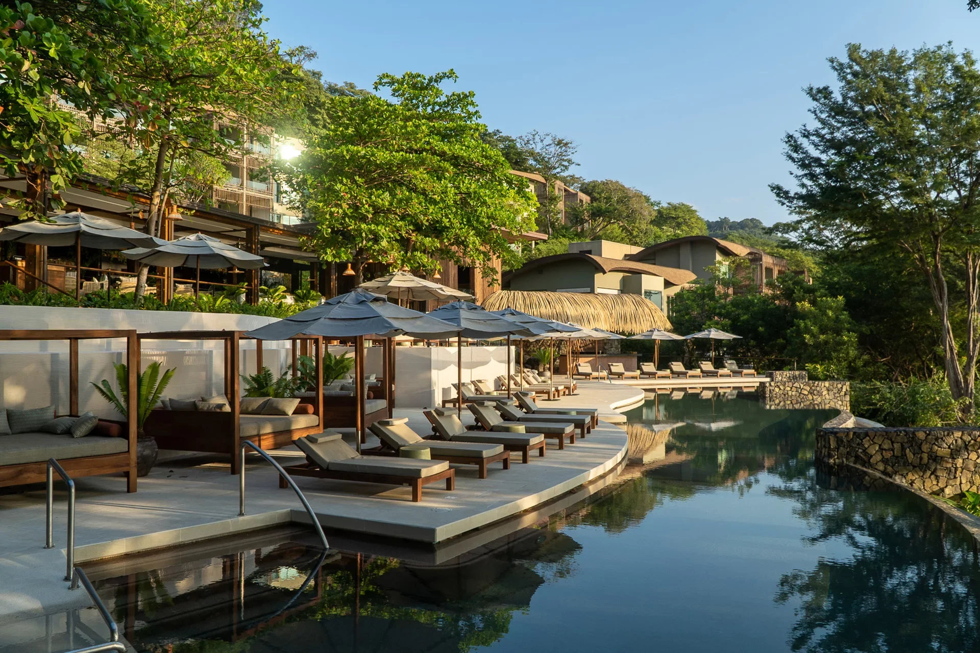 Andaz Costa Rica at Peninsula Papagayo featuring a serene rainforest-surrounded infinity pool, shaded cabanas, and modern hillside villas—perfect for a luxury eco-friendly escape in Costa Rica.